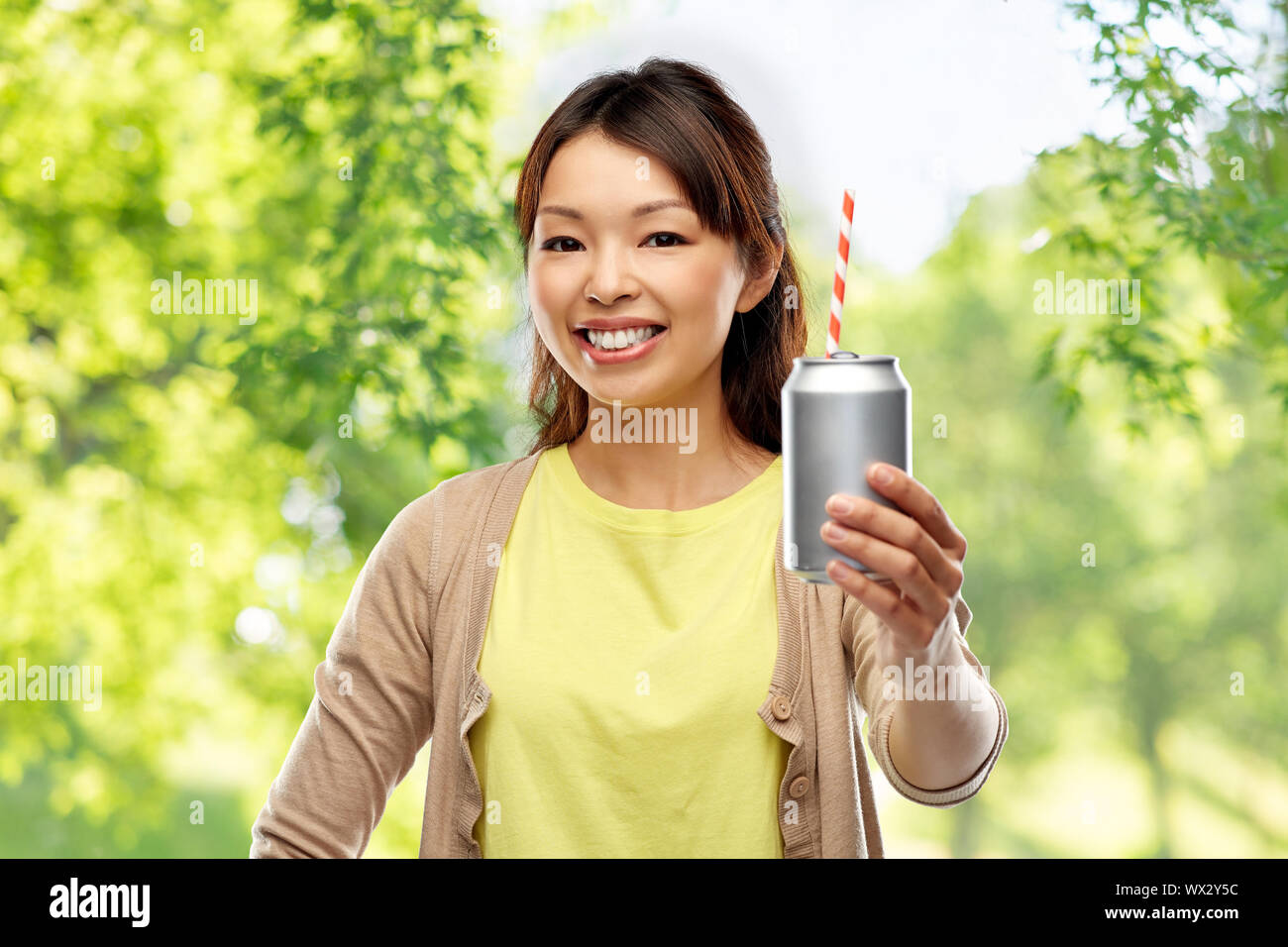Asiatische Frau mit Trinken kann über die natürlichen Hintergrund Stockfoto