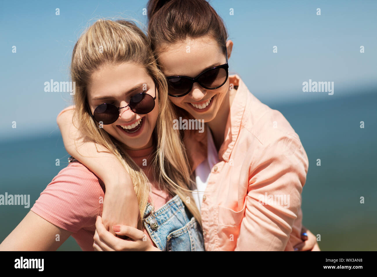 Mädchen im Teenageralter oder besten Freunden am Meer im Sommer Stockfoto