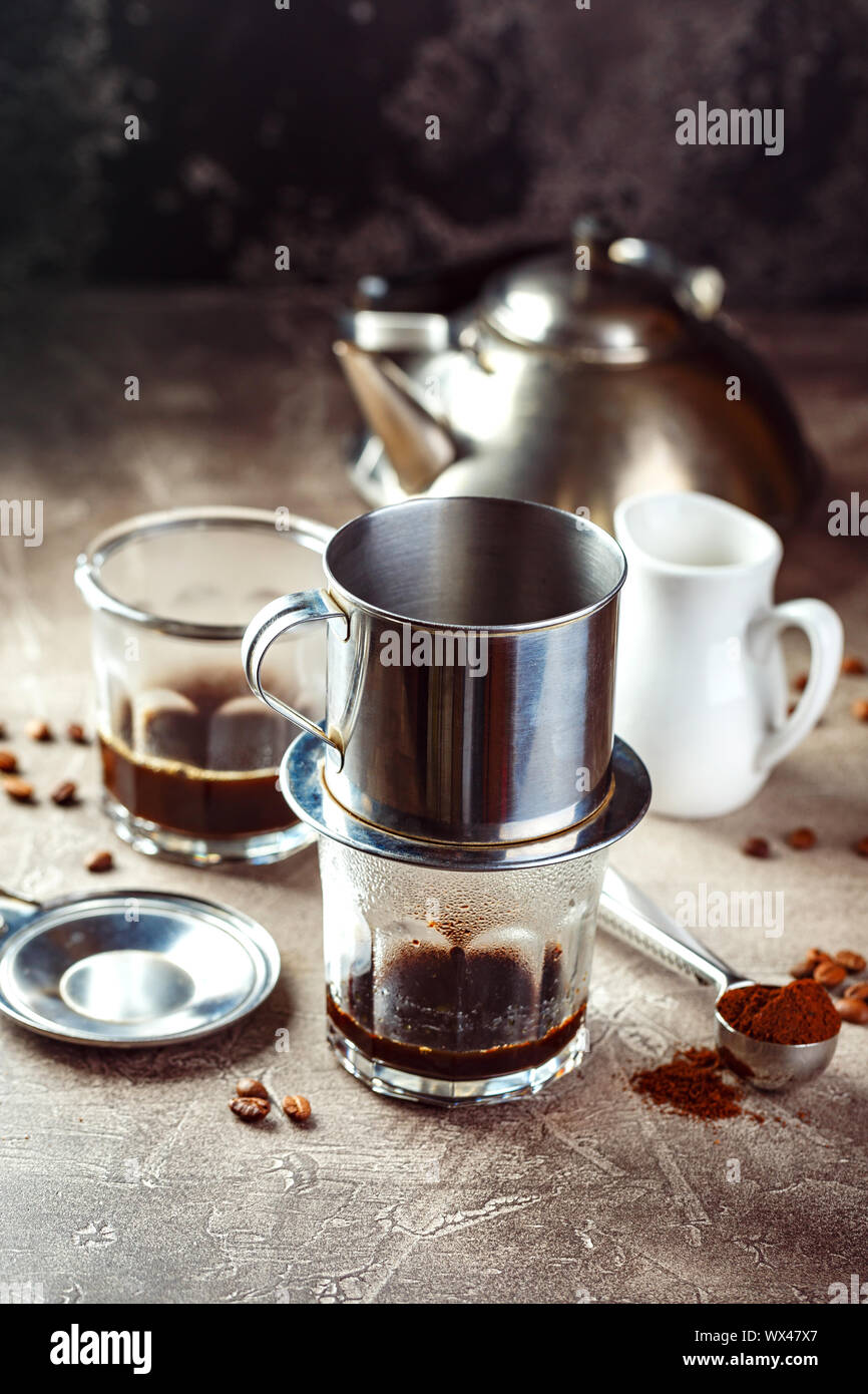 Vietnamesischen Kaffee im Glas Tassen und traditionellen Metall Kaffeemaschine phin. Traditionelle Verfahren zur Herstellung von vietnamesischen Kaffee Stockfoto