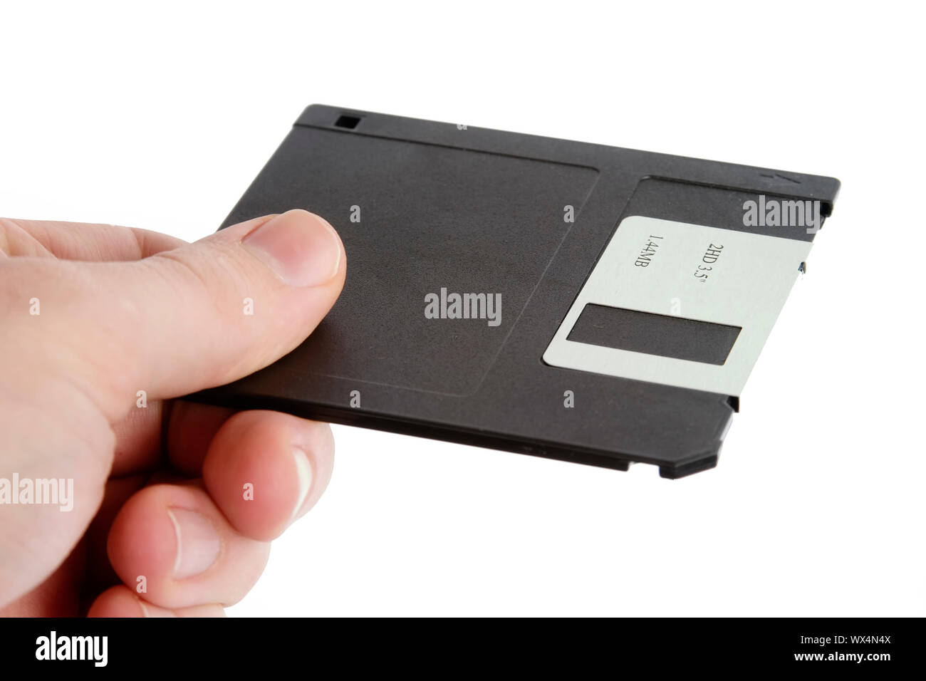 Eine Hand mit einem 3 1/2" Diskette. Auf weiß mit Freistellungspfad isoliert. Stockfoto