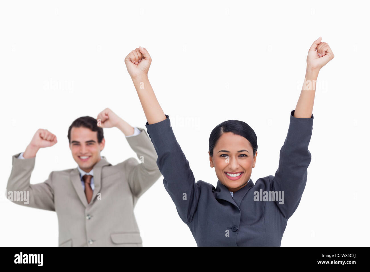 Jubelnde Verkäuferin mit Kollegen hinter ihr Stockfoto