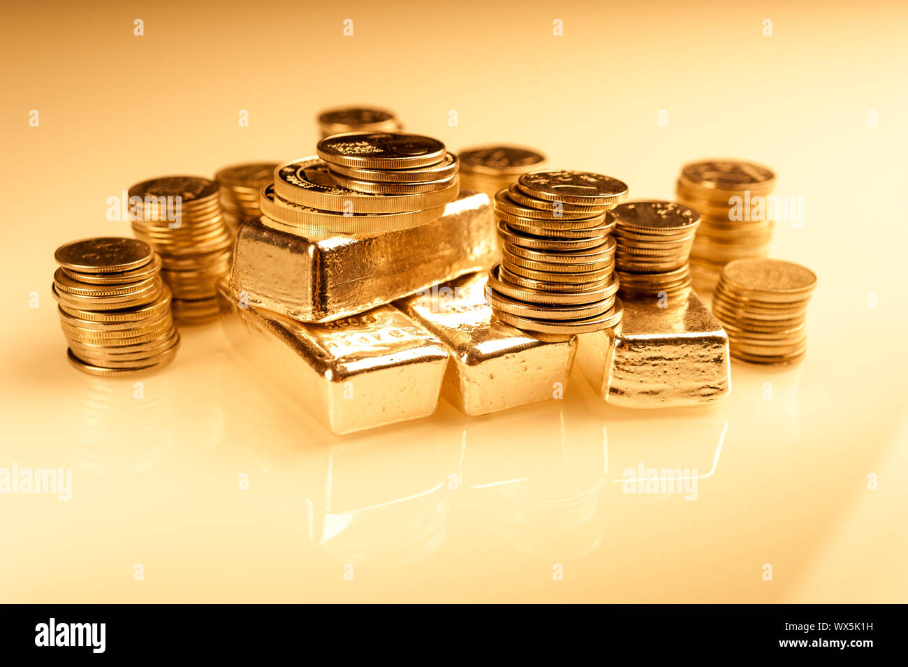 Gold Barren und Stapel von Münzen. Hintergrund für Finanzen Banken- Konzept. Handel mit Edelmetallen. Stockfoto