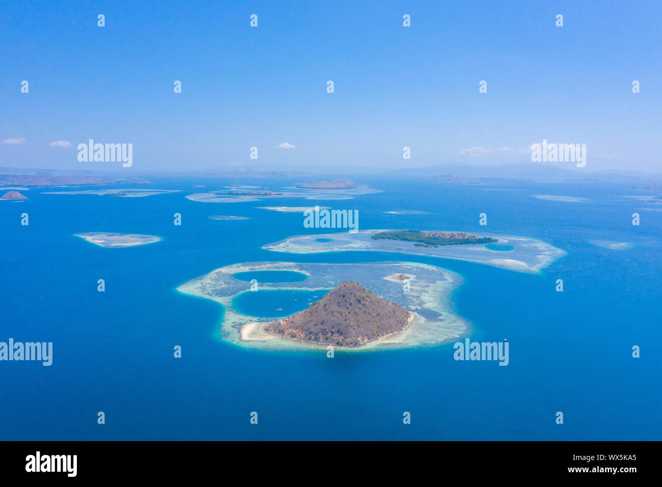 Luftaufnahme von Drone die schöne Insel Kelor mit schöner Landschaft, Sandstrand, blaues Meer, Korallenriff und und Berg in Labuan Bajo entfernt, Stockfoto