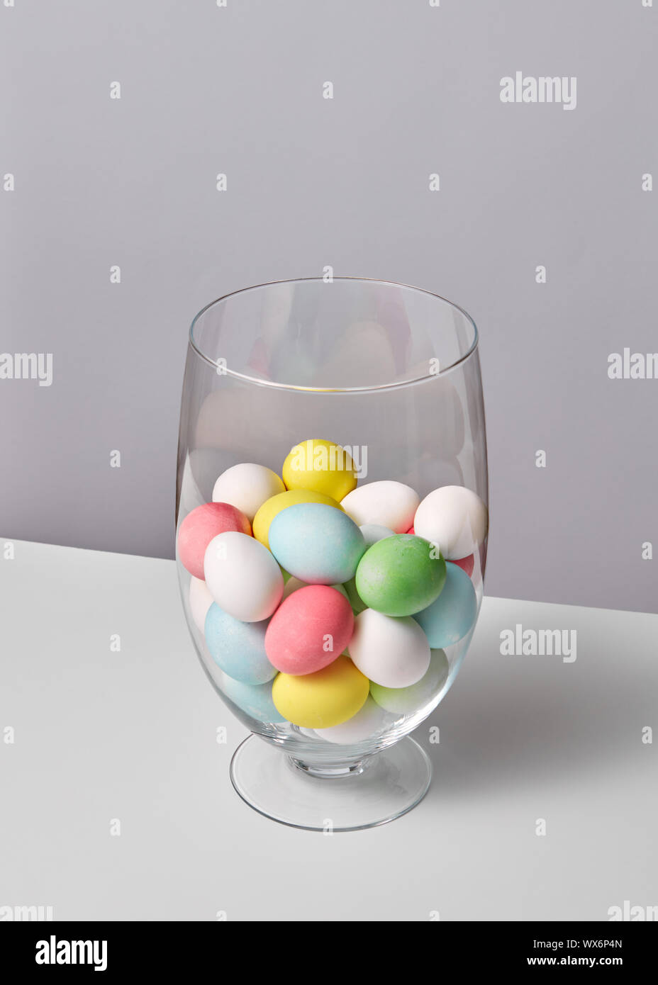 Bunt bemalte Eier in einem Glas Vase auf einem grauen Hintergrund mit Platz für Text. Ostern Konzept Stockfoto