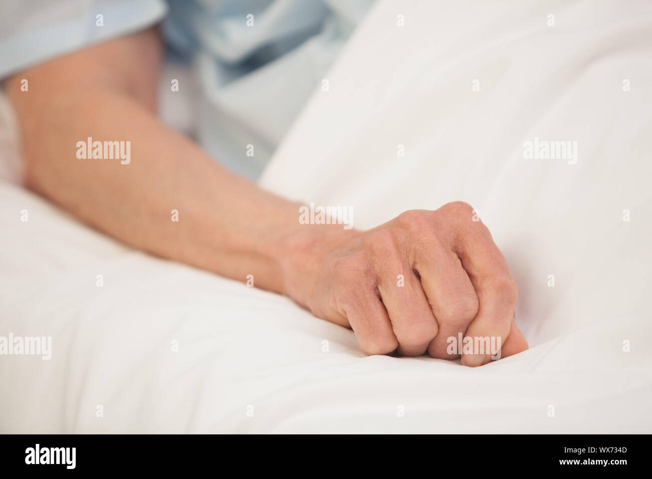 Ältere im Krankenhausbett ausgestrecktem arm Stockfoto