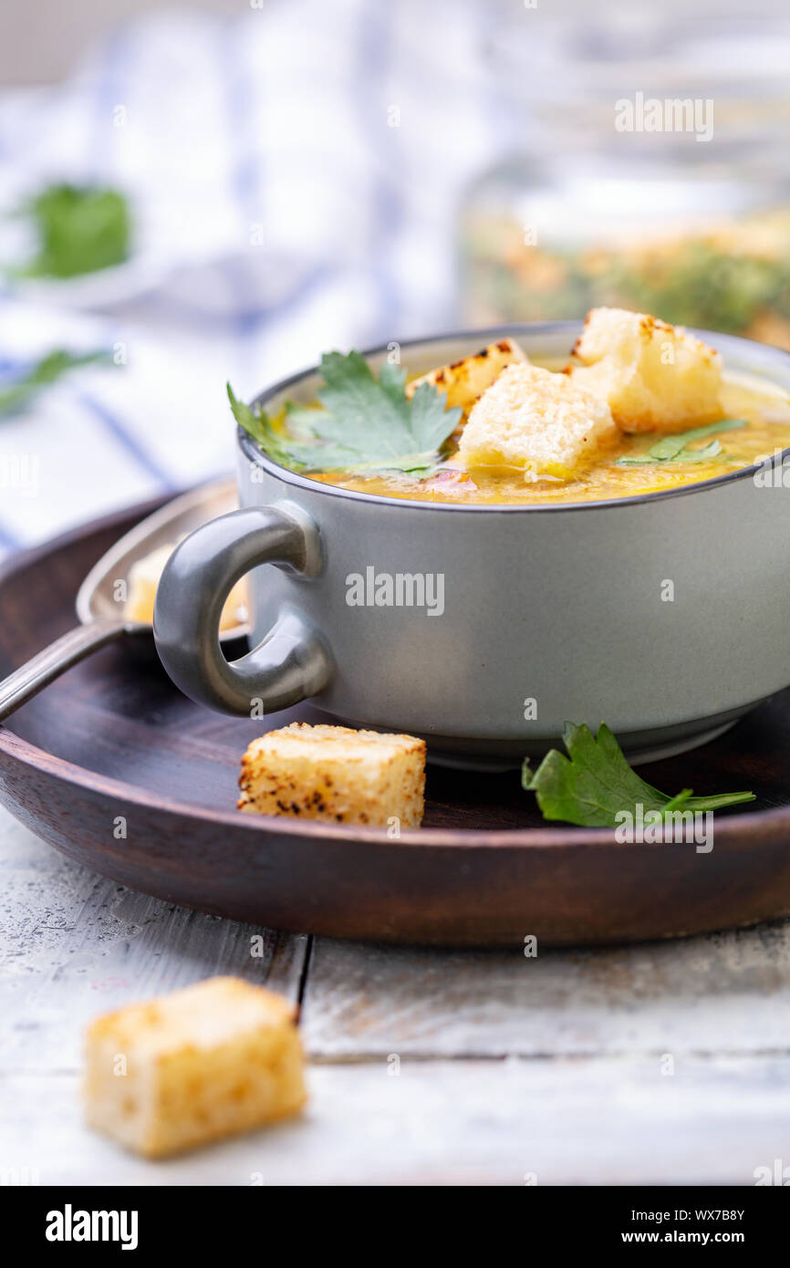 Erbsensuppe mit geräuchertem Rippchen und Croutons in eine Schüssel geben. Stockfoto