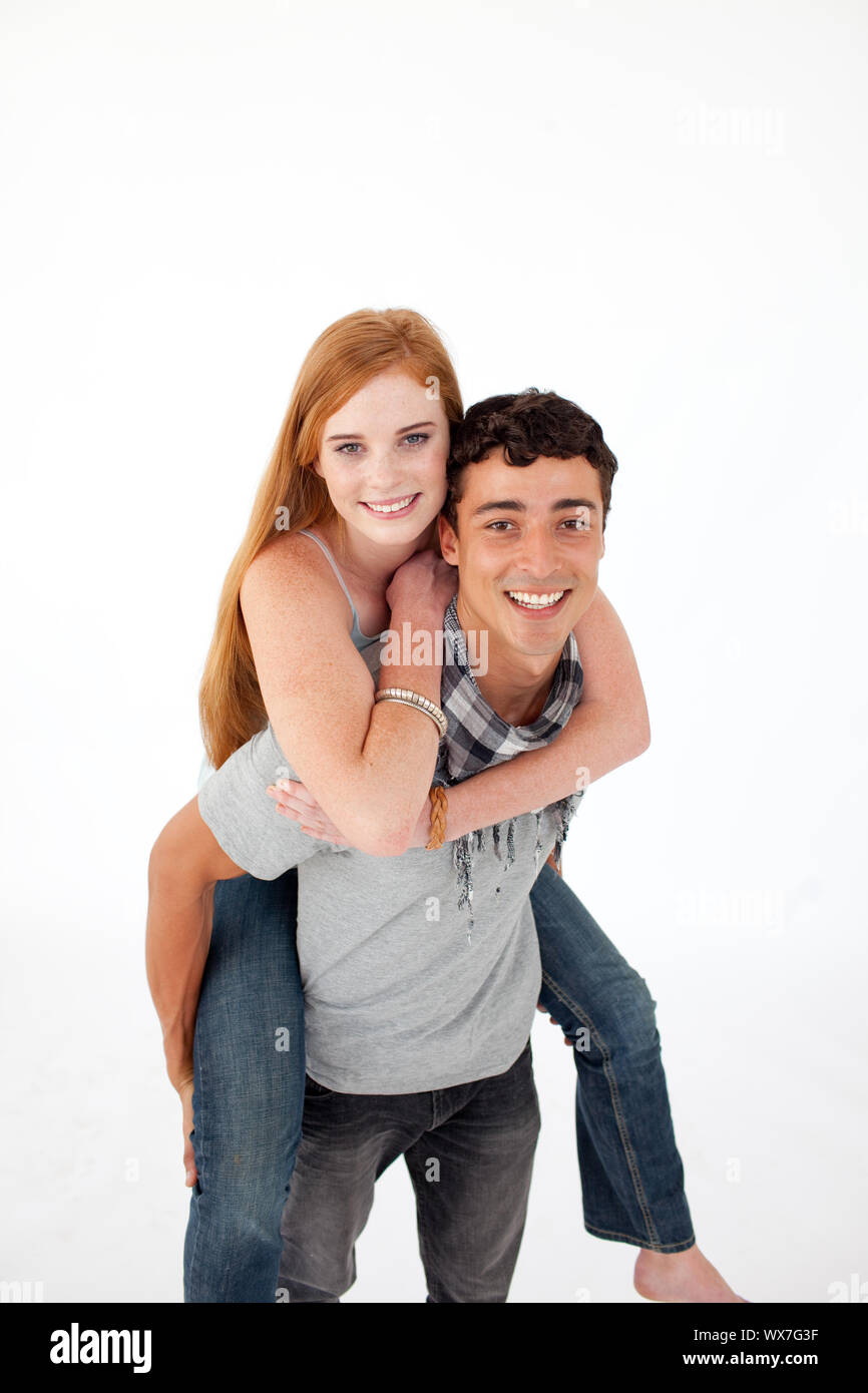 Junge seinen Freund piggyback Ride vor weißem Hintergrund geben Stockfoto