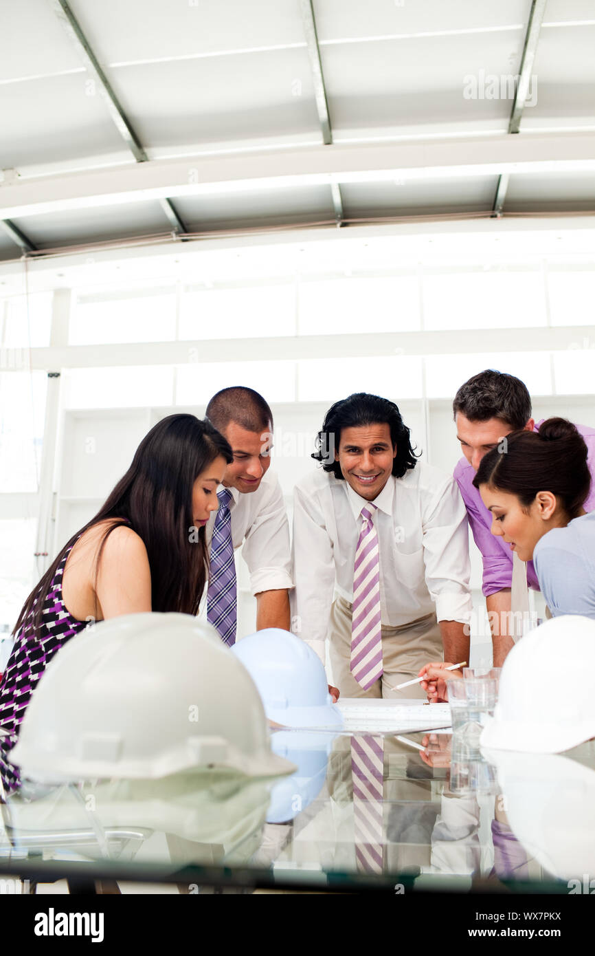 Multi-thnic Ingenieur Mitarbeiter überprüfen von Plänen in einer Sitzung Stockfoto