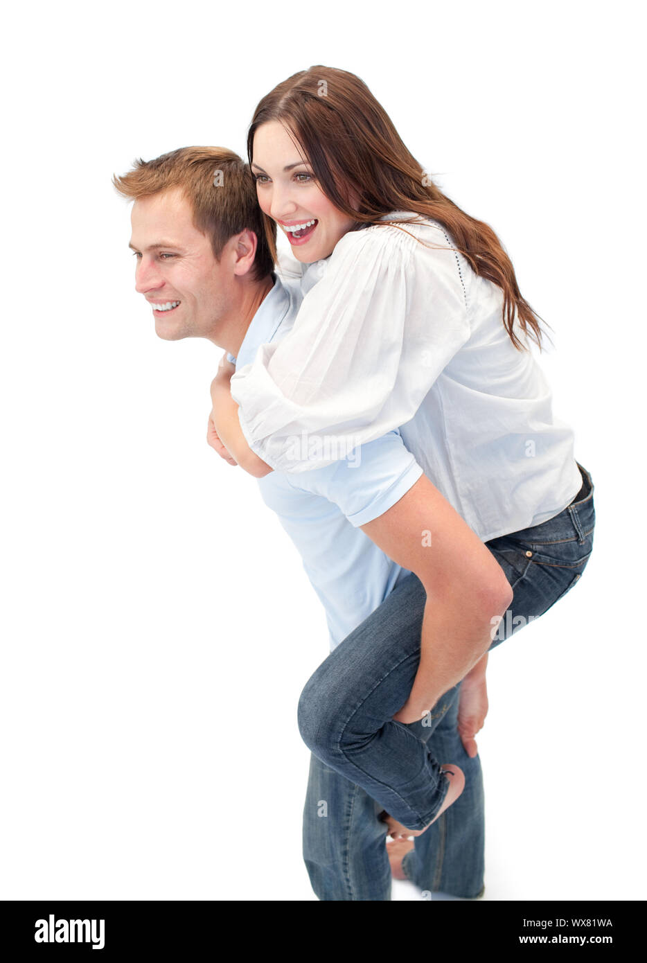 Strahlende Mann seiner Freundin piggyback Ride vor einem weißen Hintergrund geben Stockfoto