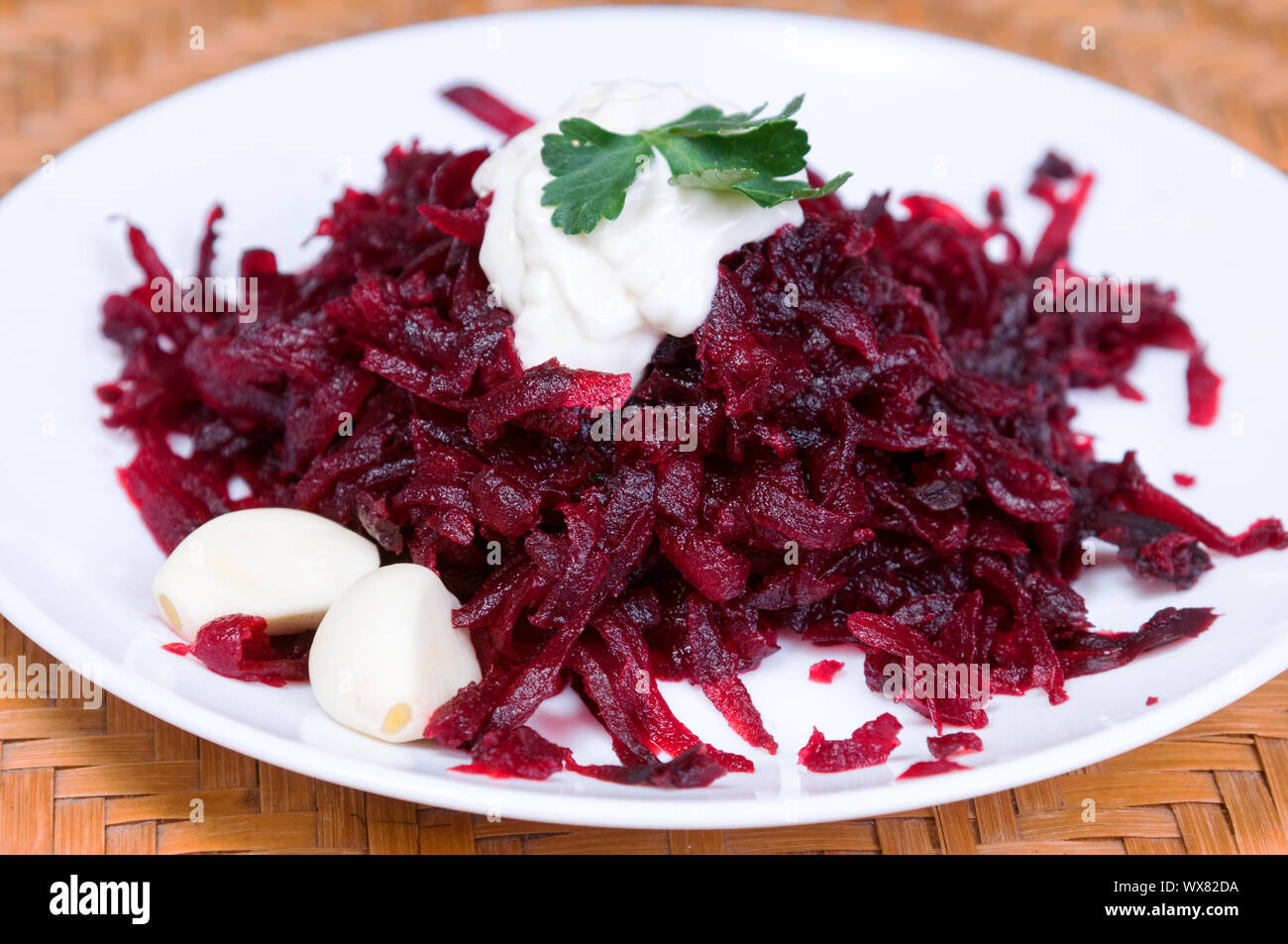 Geriebene rote Rüben mit Knoblauch in einen Teller auf dem Tisch close-up Stockfoto