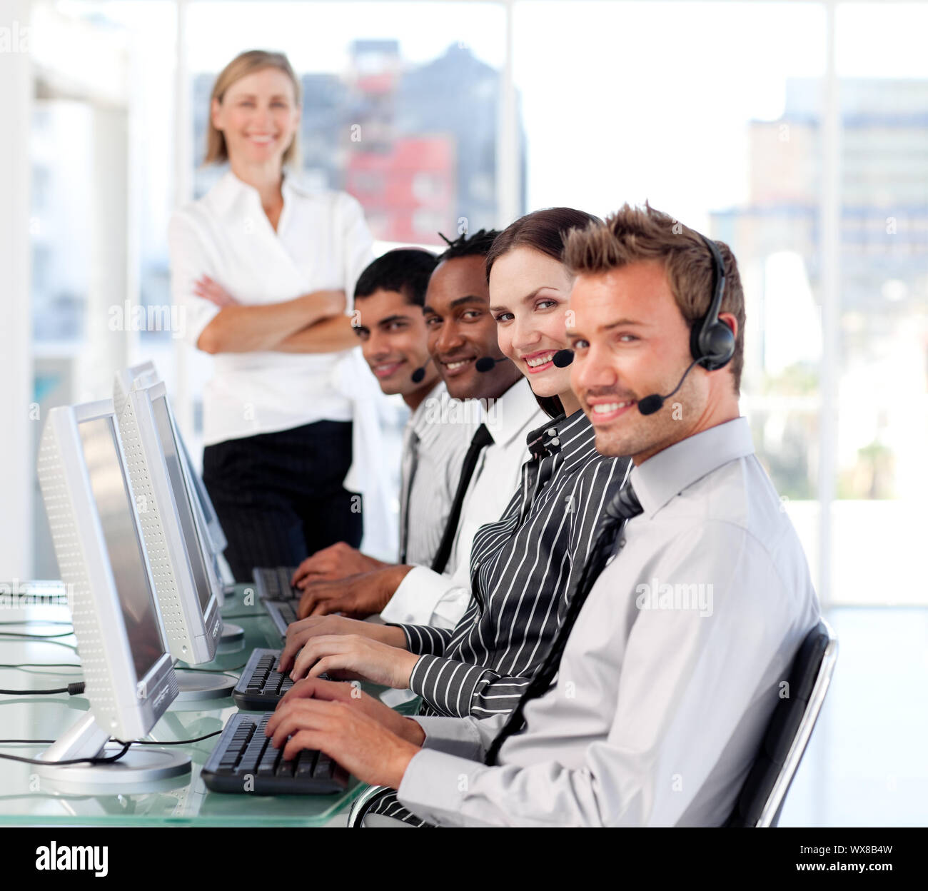 Fröhliche Anführerin Managingher Team in einem Callcenter Stockfoto