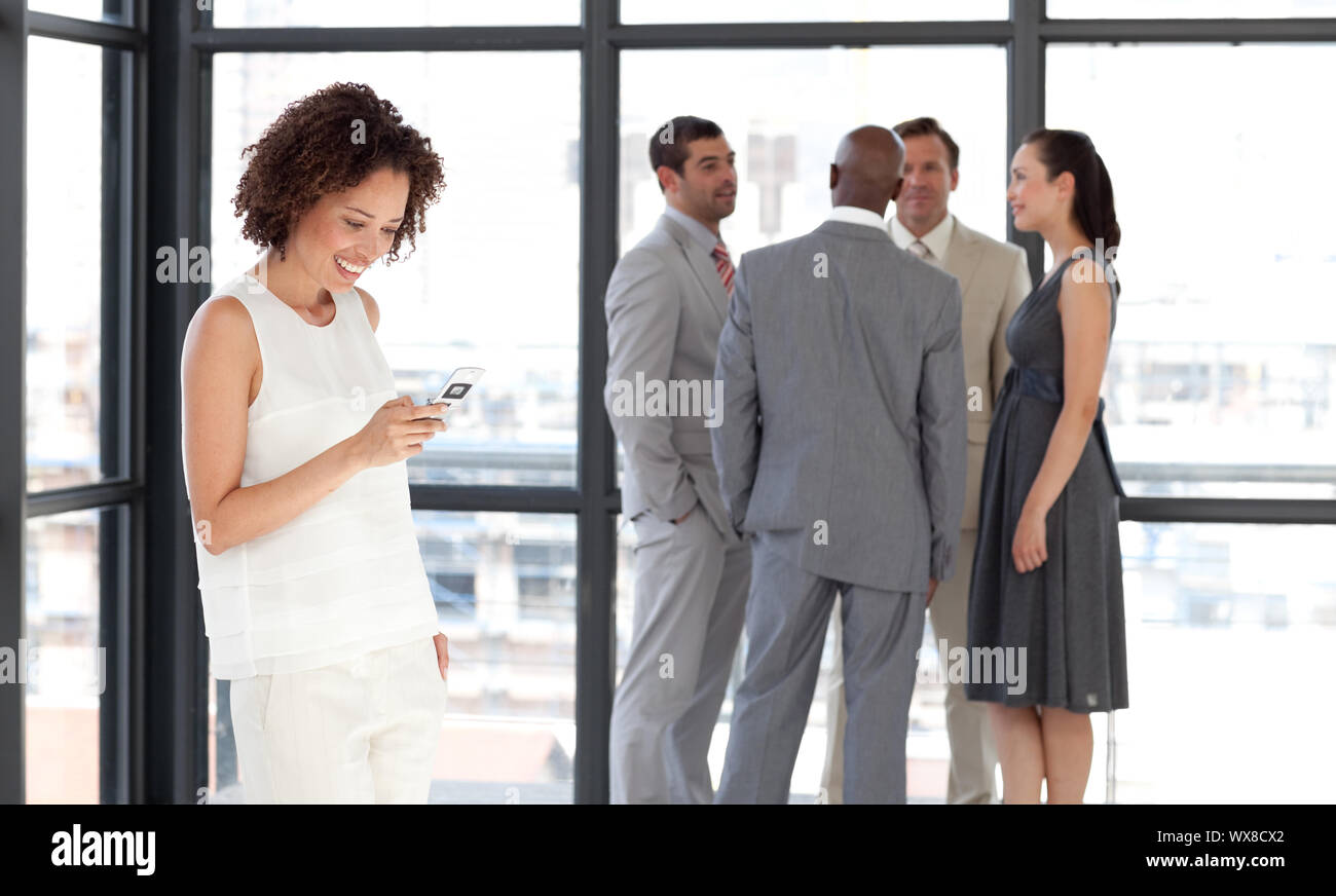 Charismatische Unternehmerin am Telefon im Büro mit ihrem team Stockfoto