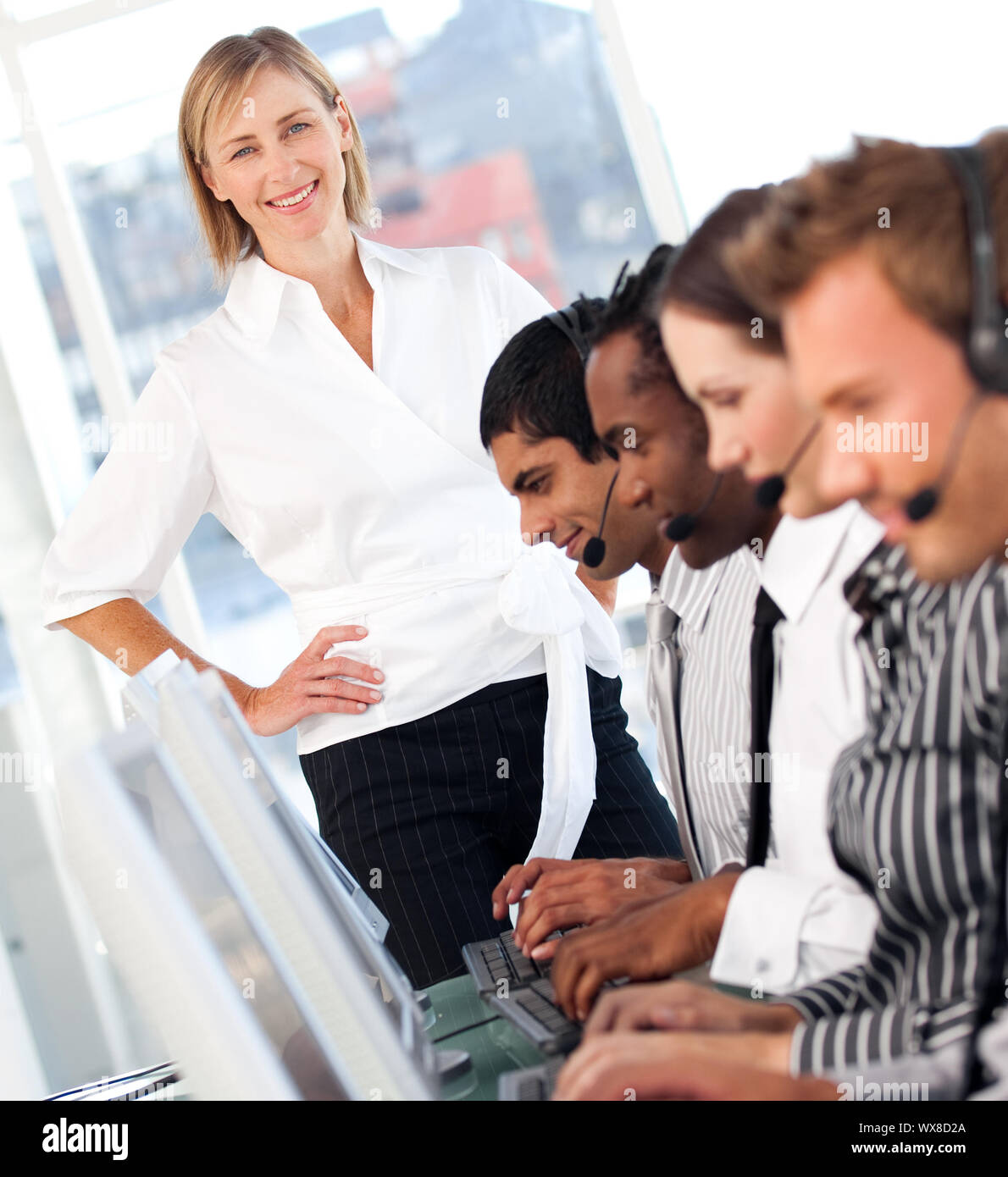 Radiant weibliche Führer mit einer Mannschaft auf ein Call Center Stockfoto