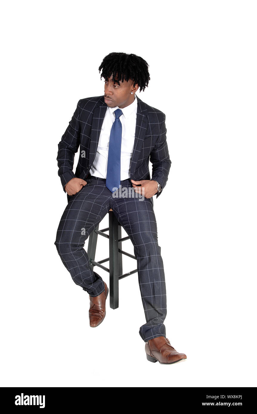 Die Jungen gut aussehenden schwarzen Mann sitzt auf Stuhl Stockfoto