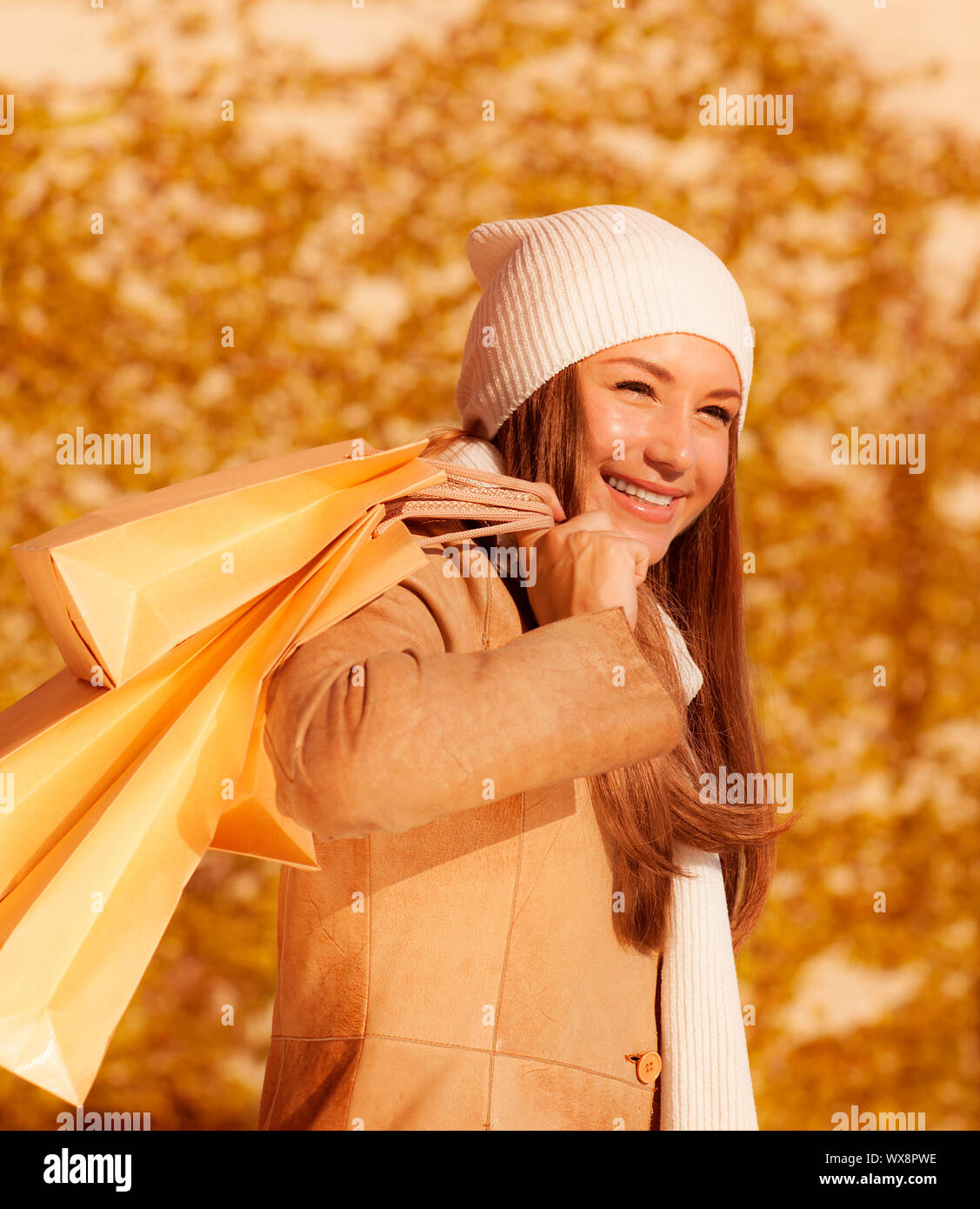 Foto von schönen Mädchen mit Einkaufstasche, Nahaufnahme Portrait von attraktiven weiblichen auf herbstlaub Hintergrund isoliert, junge Dame ihre günstig online Stockfoto