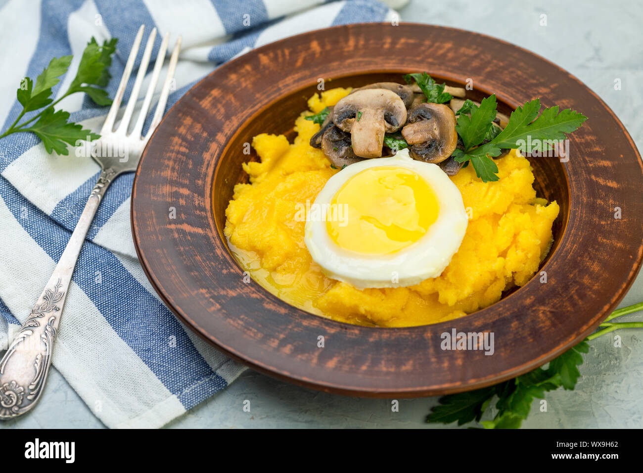 Polenta mit karamellisierten Pilze, Ei und Petersilie. Stockfoto