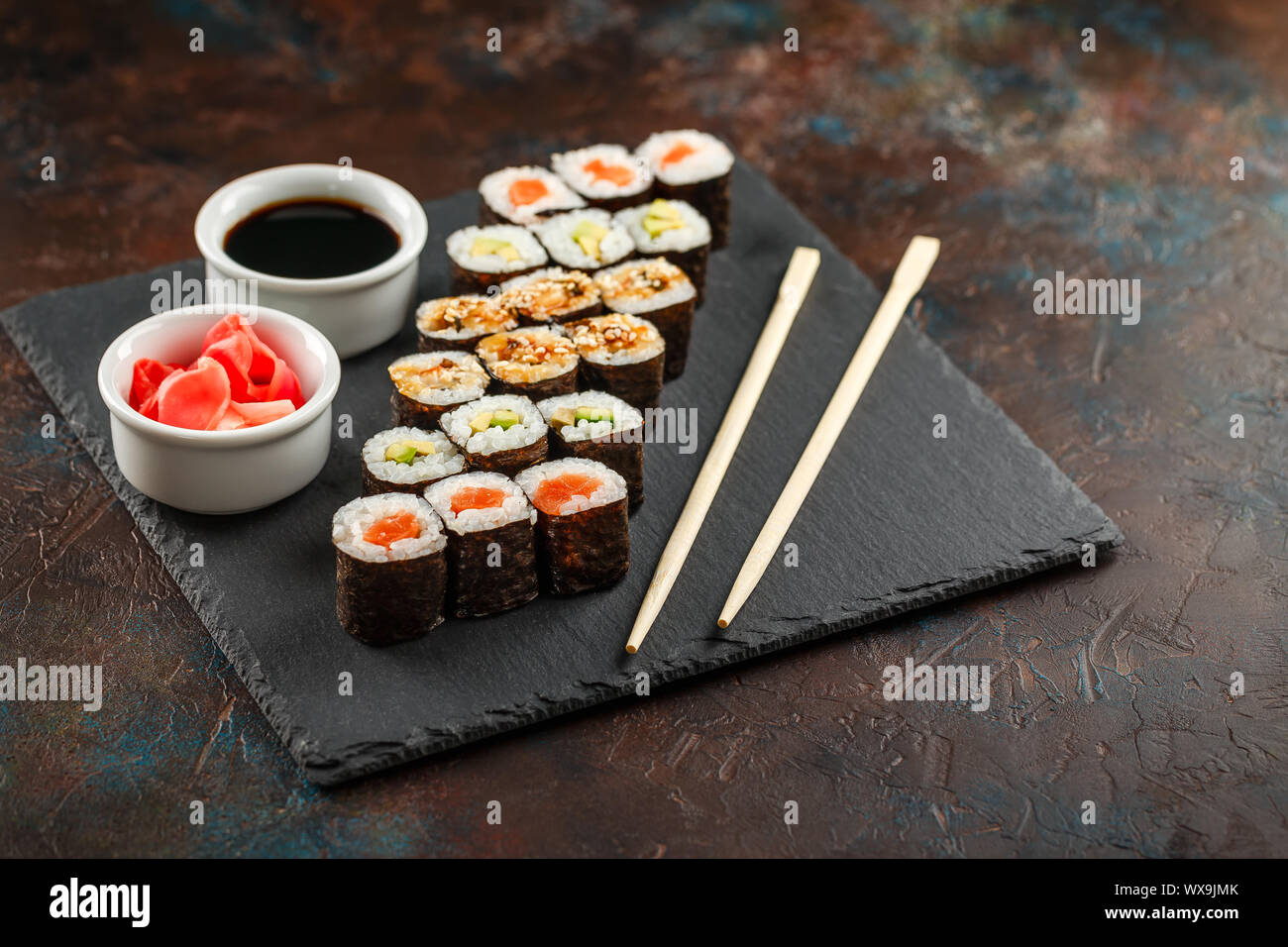 Japanisches Sushi auf einem rustikalen dunklen Hintergrund. Stockfoto