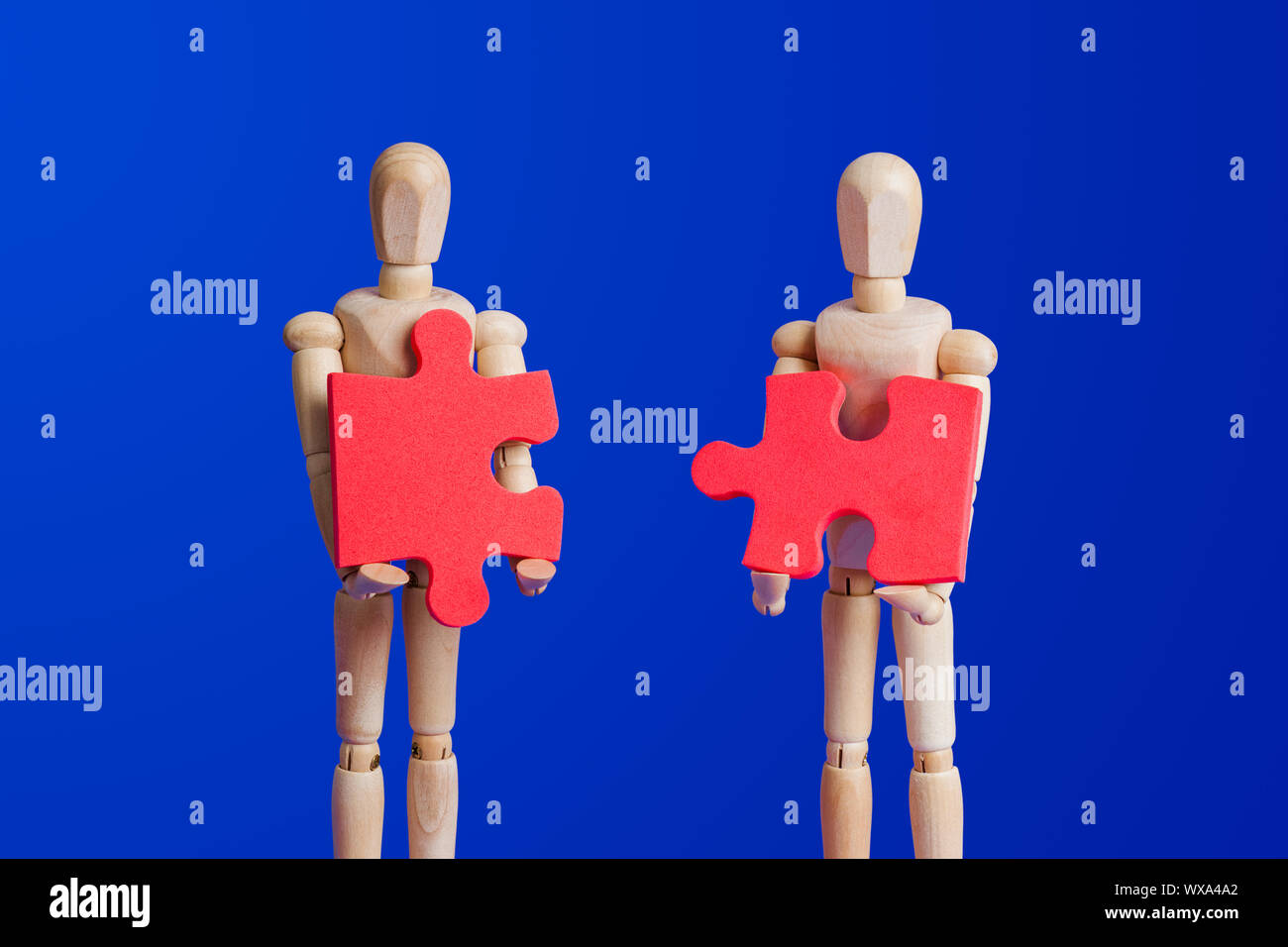 Holzspielzeug Figuren mit Puzzle auf Blau Stockfoto