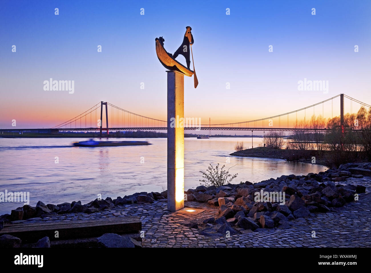 Beleuchtete Skulptur Fährmann am Rhein bank im Abendlicht, Emmerich, Deutschland, Europa Stockfoto