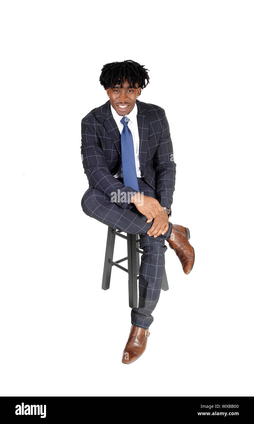 Die Jungen gut aussehenden schwarzen Mann sitzt auf Stuhl im Anzug Stockfoto