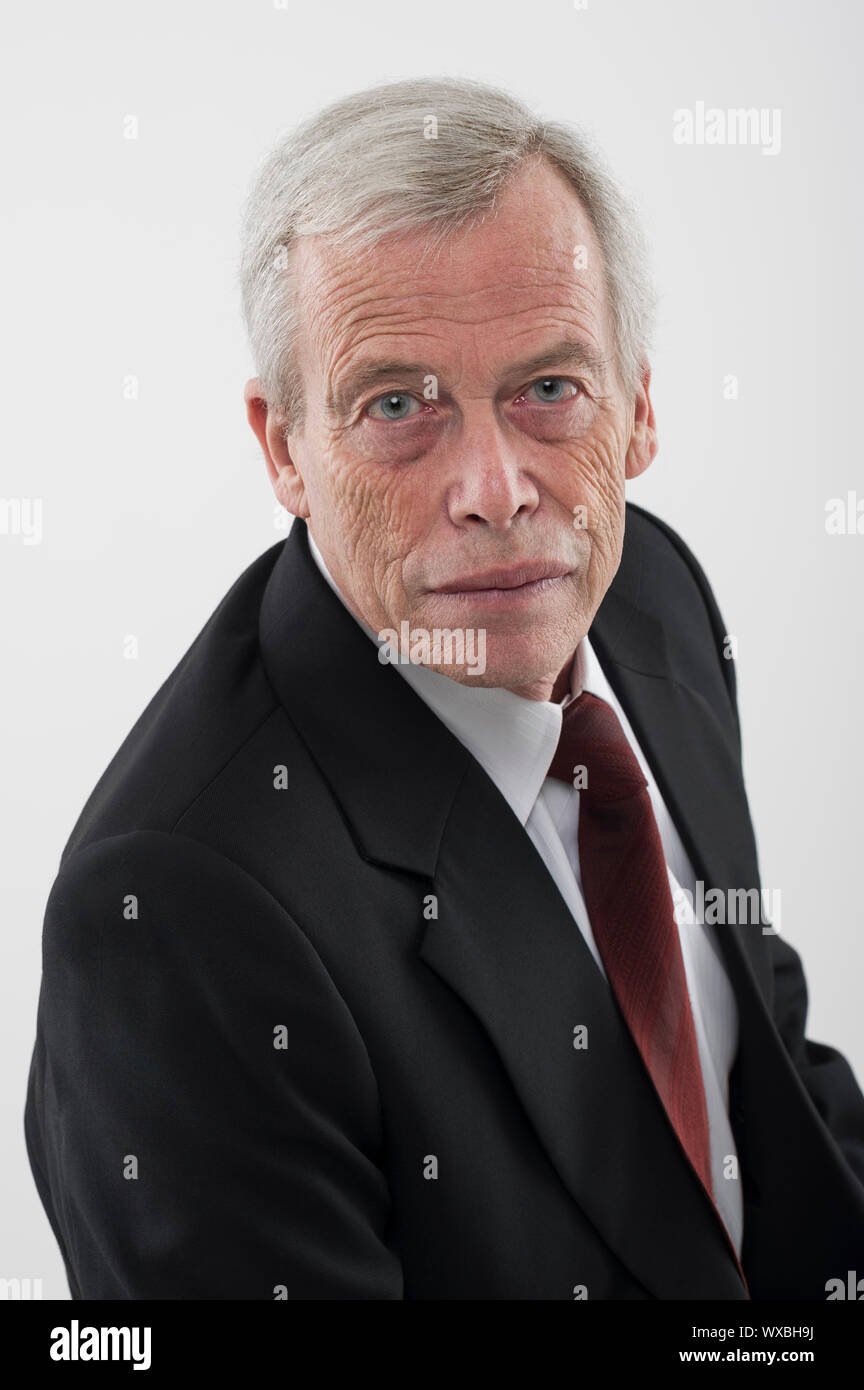 Hohen Winkel studio Portrait einer schweren gut aussehender Grauhaariger älterer Mann in Anzug und Krawatte, mit Blick auf die Kamera Stockfoto