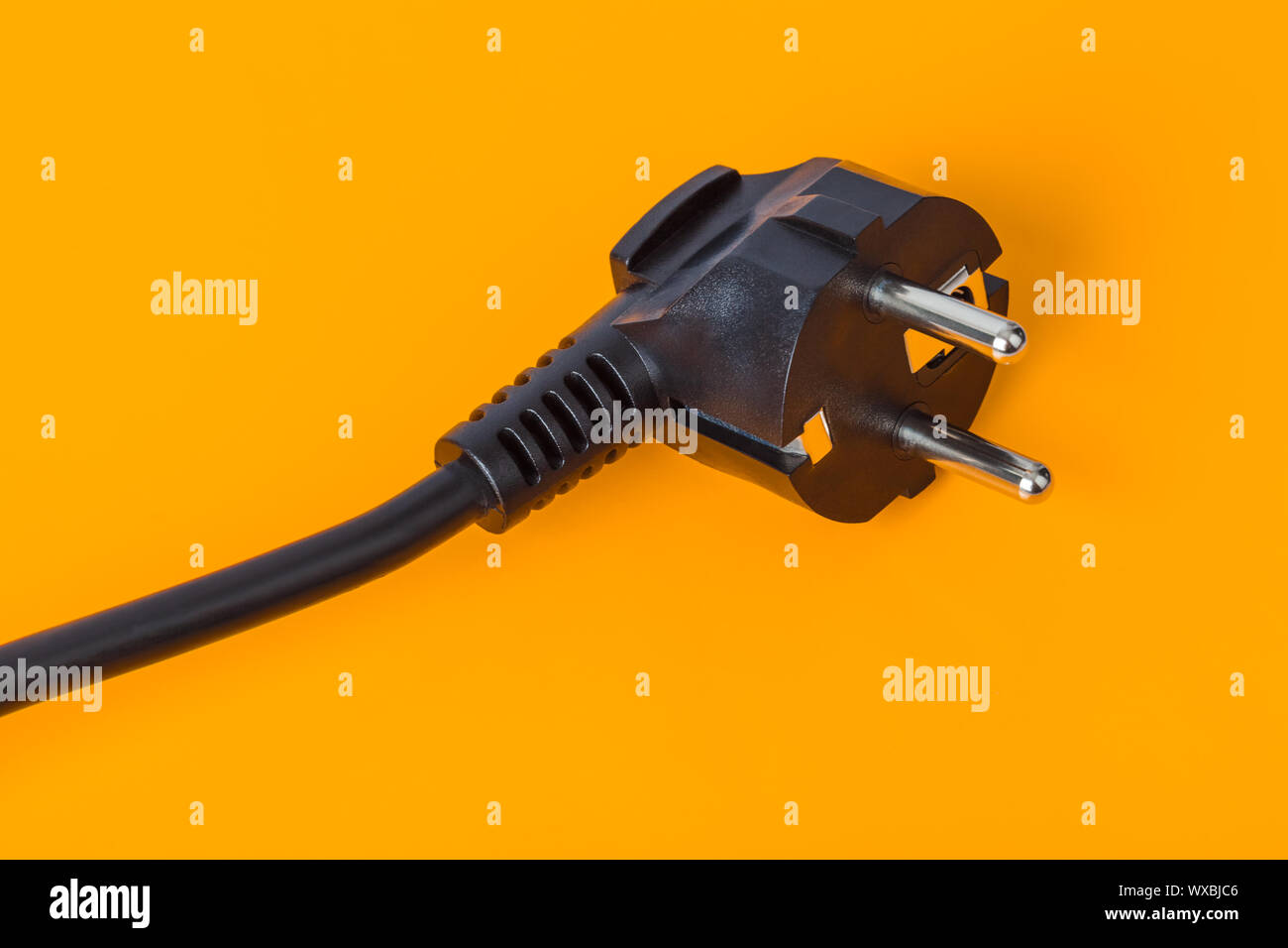 Die elektrischen Stecker auf orangefarbenem Hintergrund Stockfoto