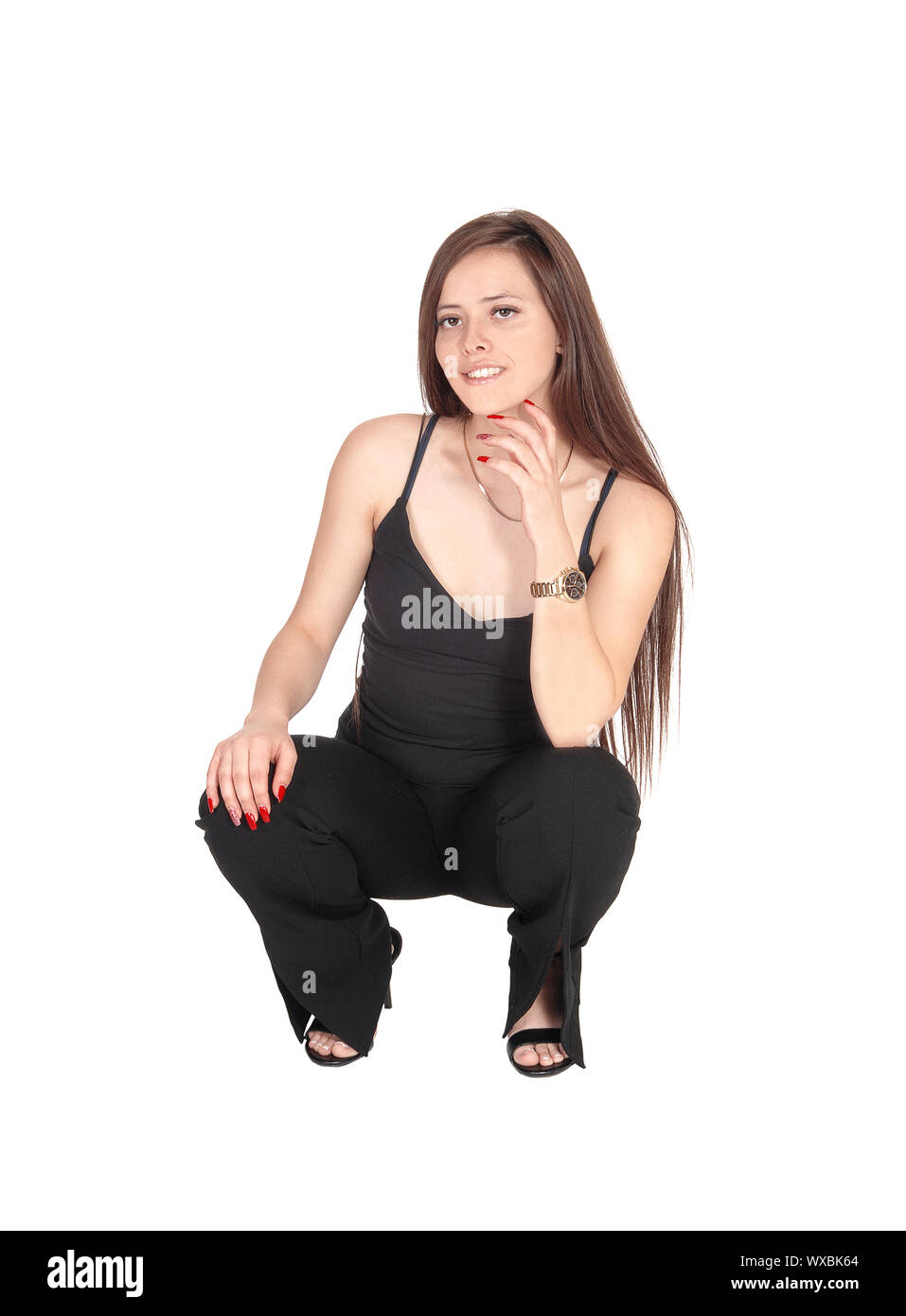 Reizende junge Frau kauern auf dem Boden Stockfoto