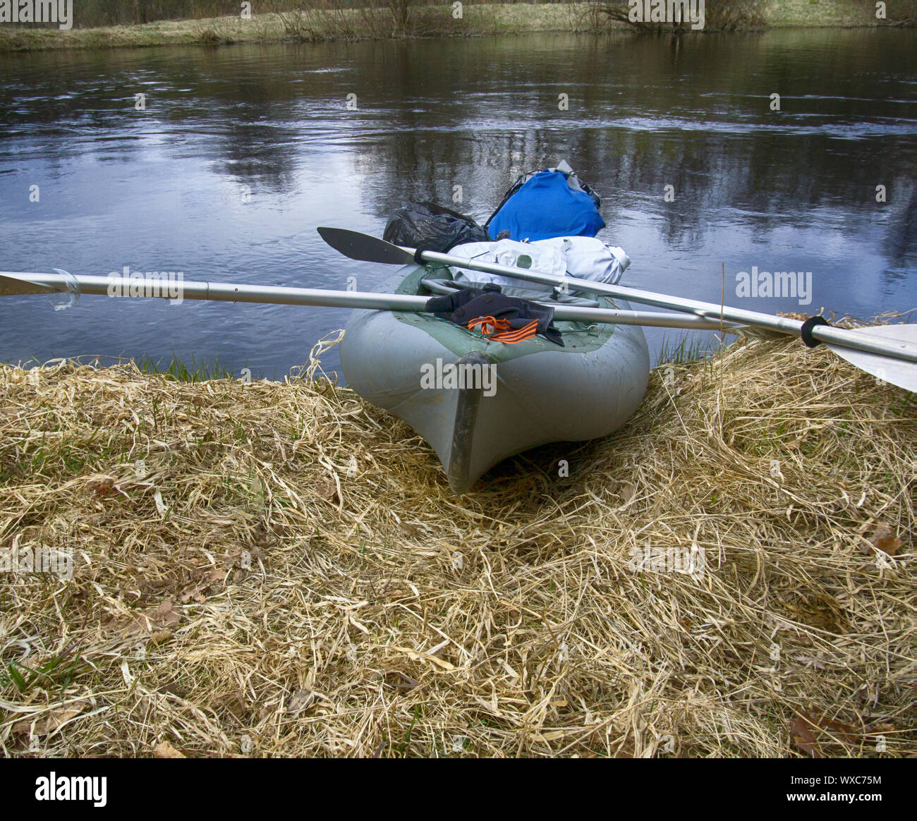 Kajaks vertäut am Ufer des Teiches in Gras im Frühling. Stockfoto