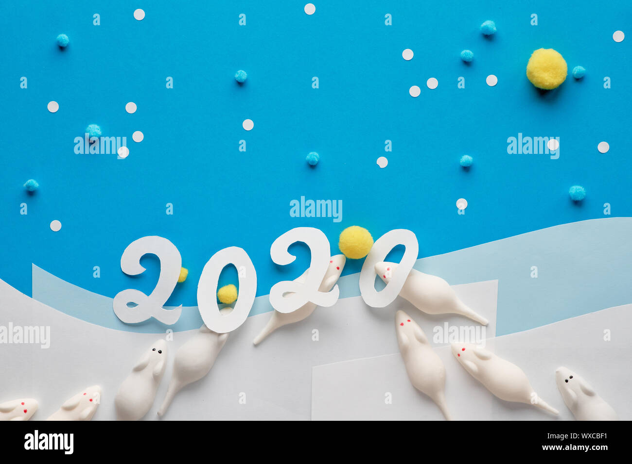 Frohes Neues Jahr 2020! Creative Paper flach in Blau und Weiß mit Marshmallow Mäuse gehen für flauschig gelbe Bälle auf Schnee Hintergrund mit Nummer 2020 Stockfoto