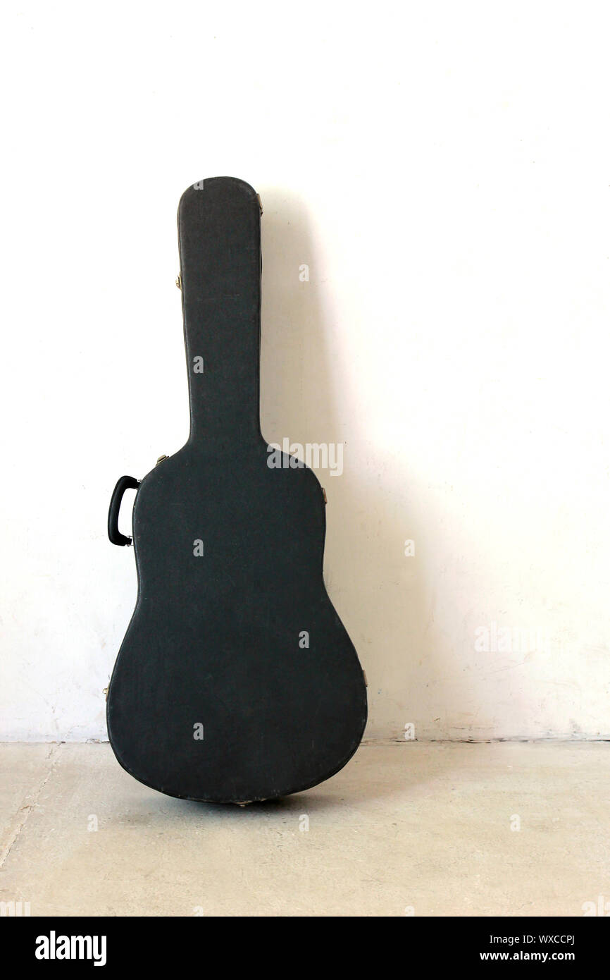 Die alten Gitarrenkoffer auf weißen Wand Stockfoto