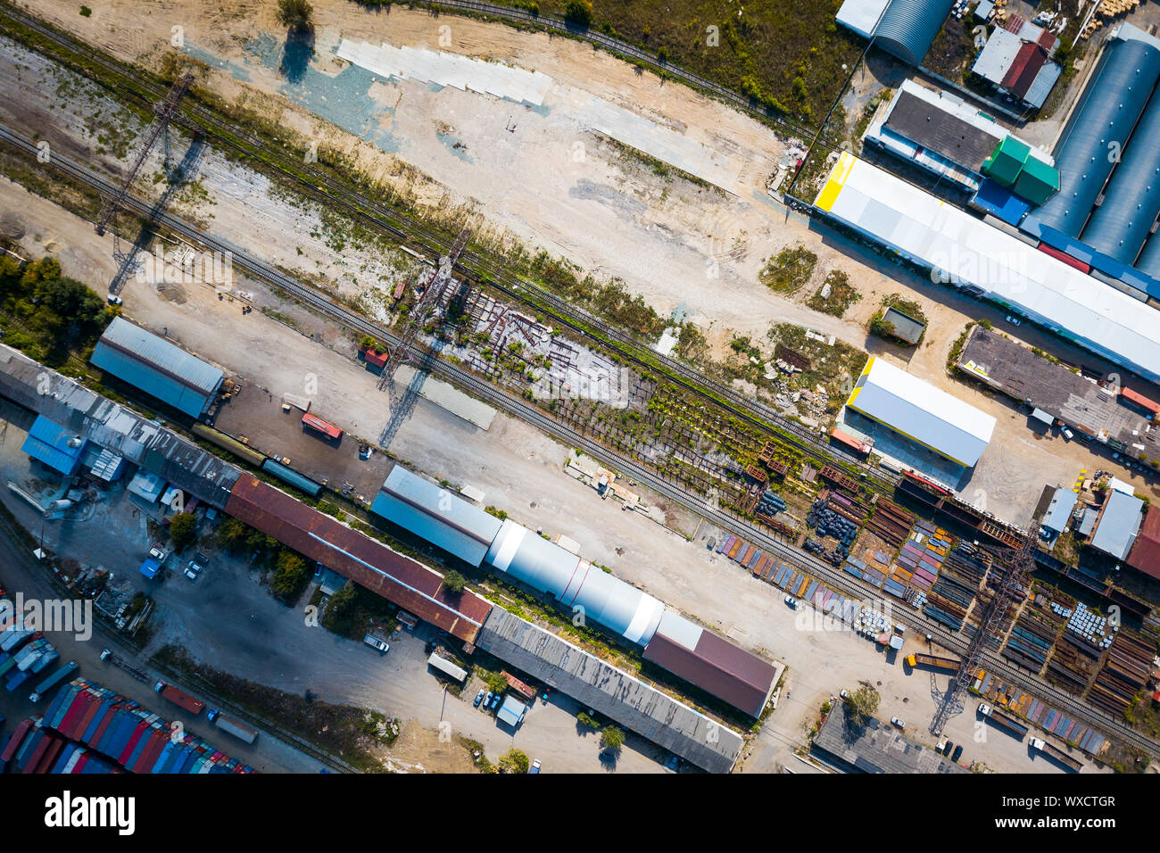 Ansicht von oben in die industrielle Zone: Eisenbahnschienen, Garagen, Lagerhallen, Container zur Lagerung von Waren. Das Konzept der Lagerung der Waren Importeure, Expor Stockfoto