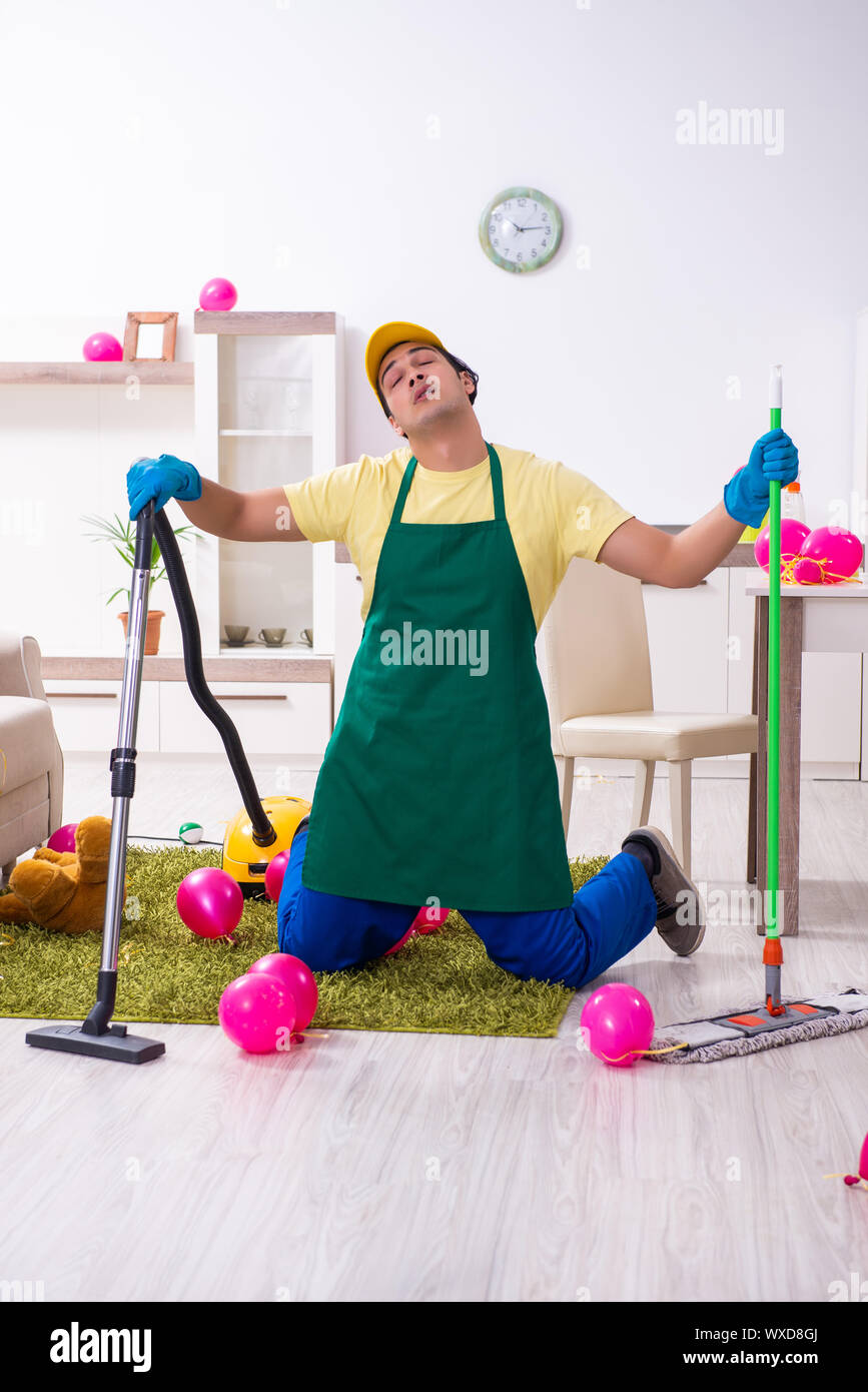 Junge männliche Auftragnehmer tun Hausarbeit nach Partei Stockfoto