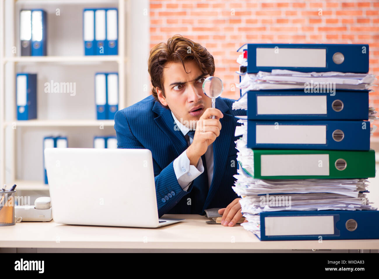 Junge elegante Mann mit zu viel Arbeit unzufrieden Stockfoto