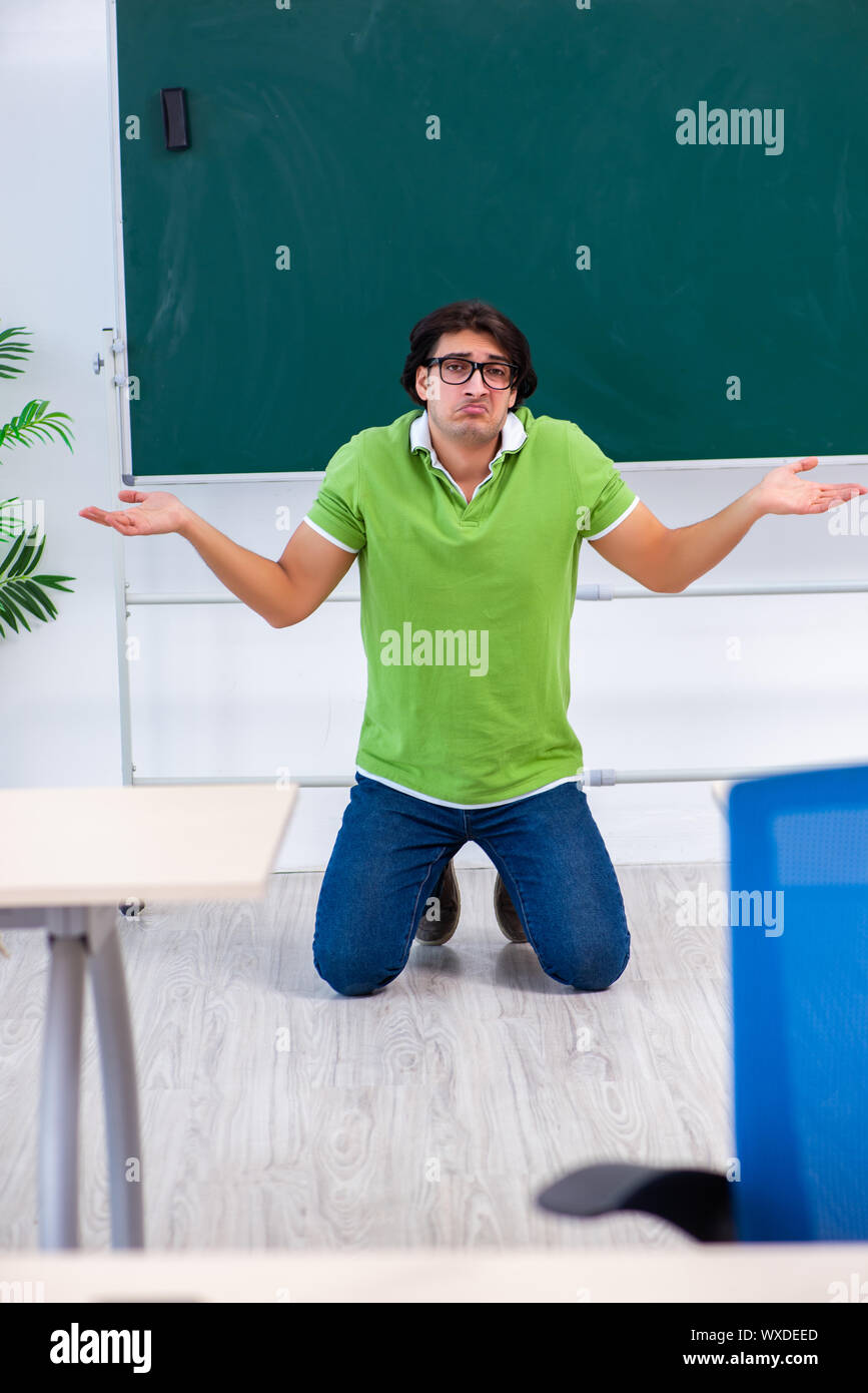 Junge männliche Studenten vor der grünen Platine Stockfoto