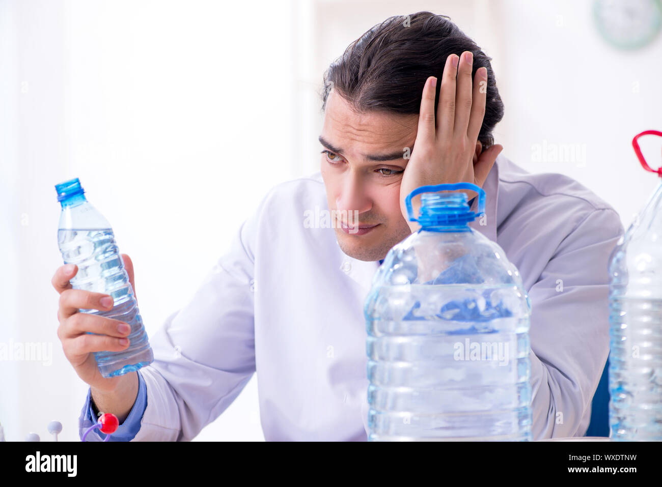 Junge männliche Chemiker im Labor experimentieren Stockfoto