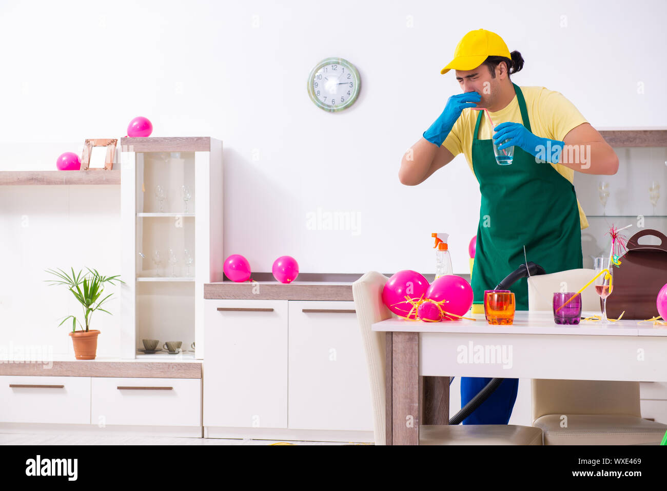 Junge männliche Auftragnehmer tun Hausarbeit nach Partei Stockfoto