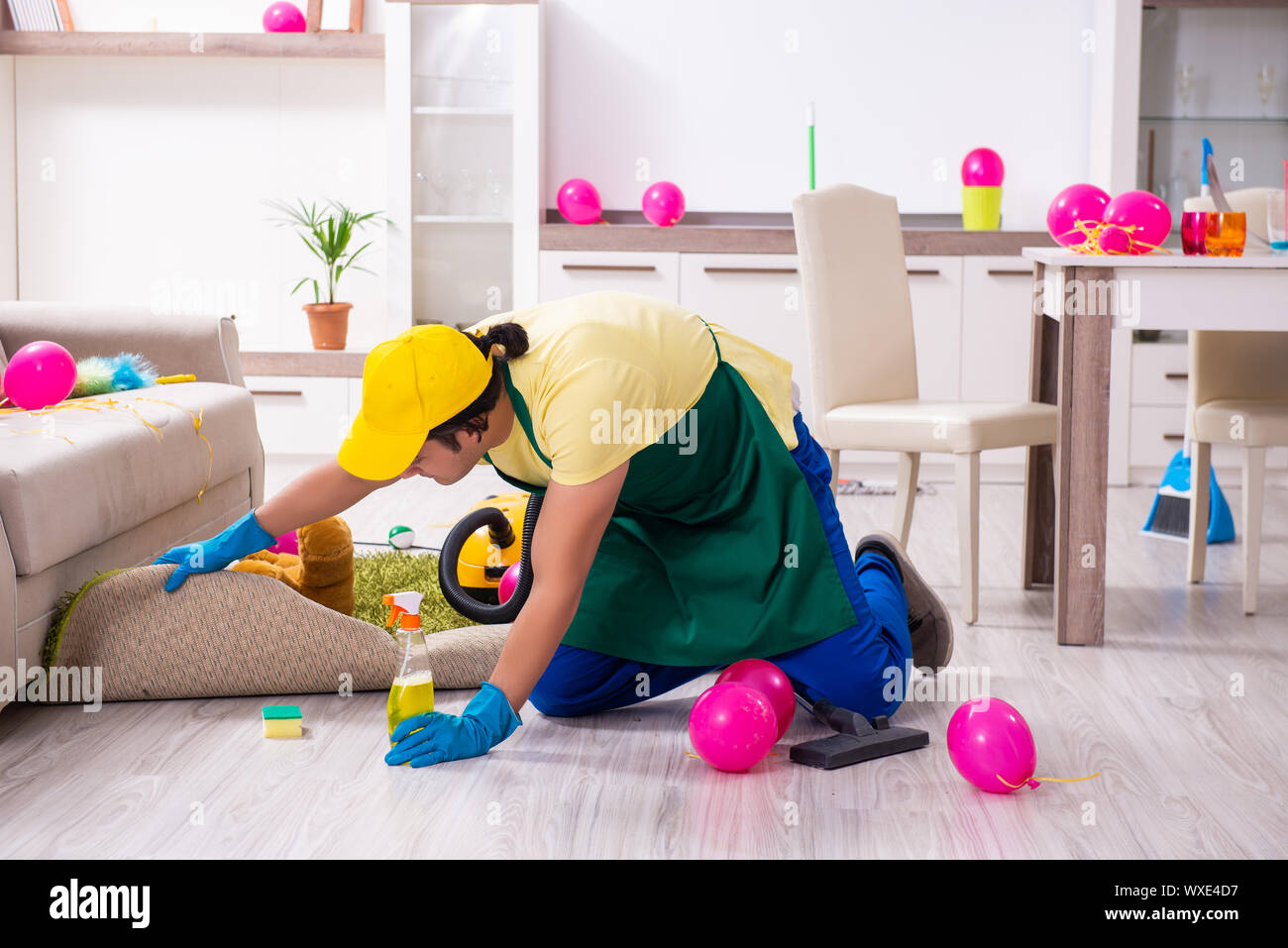 Junge männliche Auftragnehmer tun Hausarbeit nach Partei Stockfoto