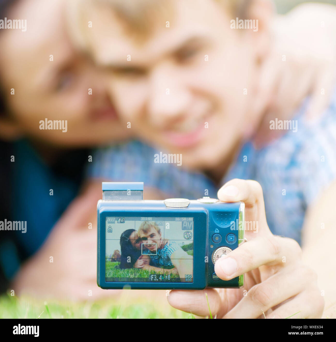 Junge emotionale Happy teenage Paar unter Bild auf Gras im City Park Stockfoto