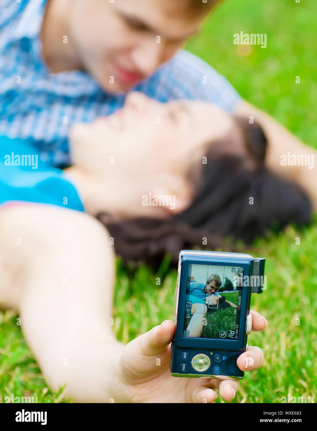 Junge emotionale Happy teenage Paar unter Bild auf Gras im City Park Stockfoto