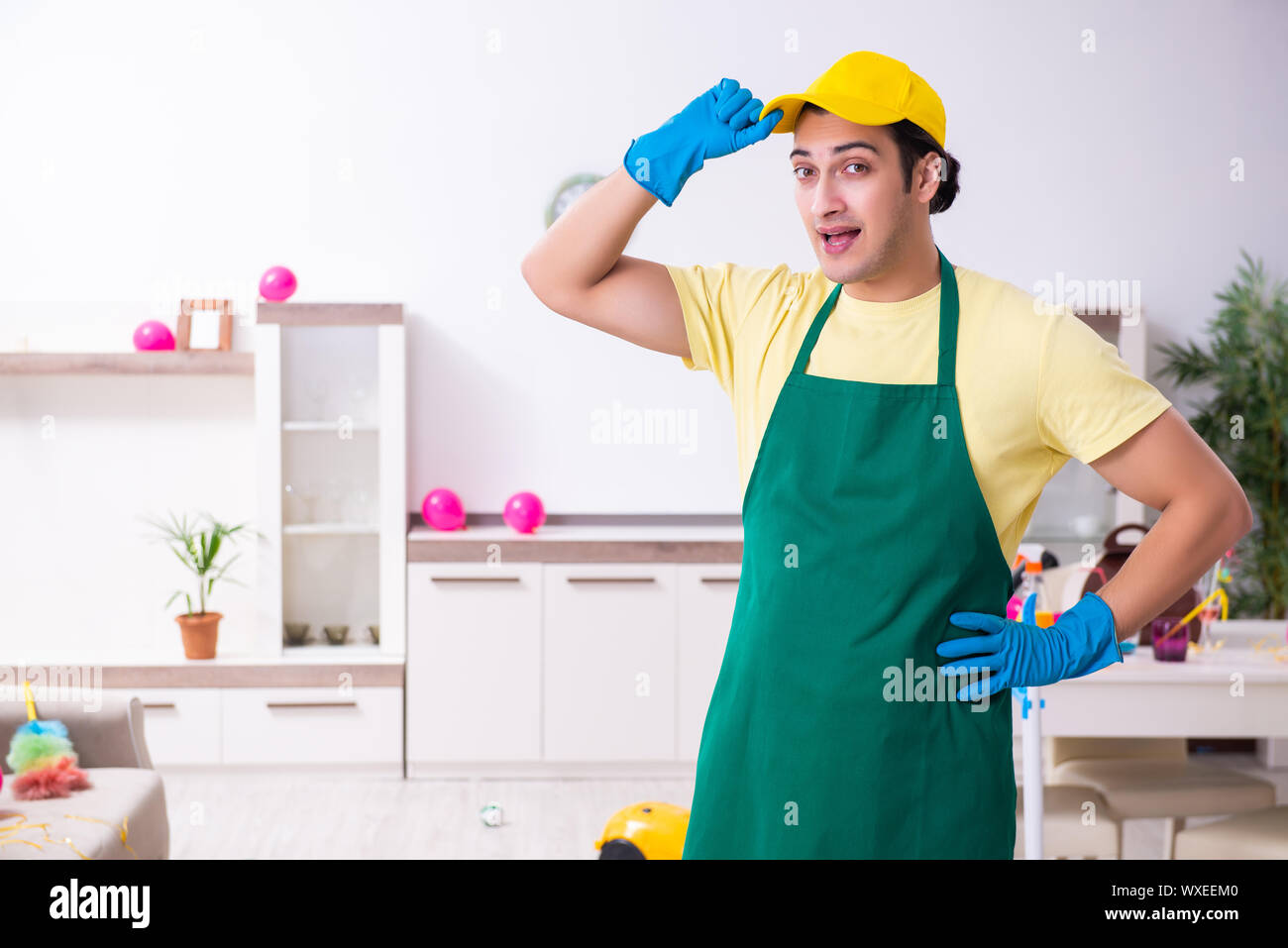 Junge männliche Auftragnehmer tun Hausarbeit nach Partei Stockfoto