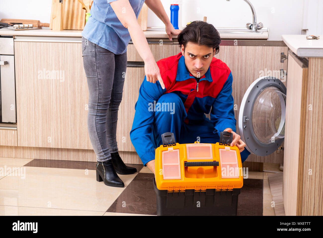 Junge männliche Handwerker Reparatur Waschmaschine Stockfoto