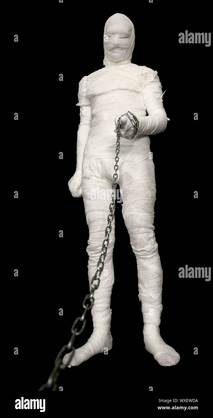 Mann im Kostüm Mumie mit Kette an der Leine zu halten Stockfoto