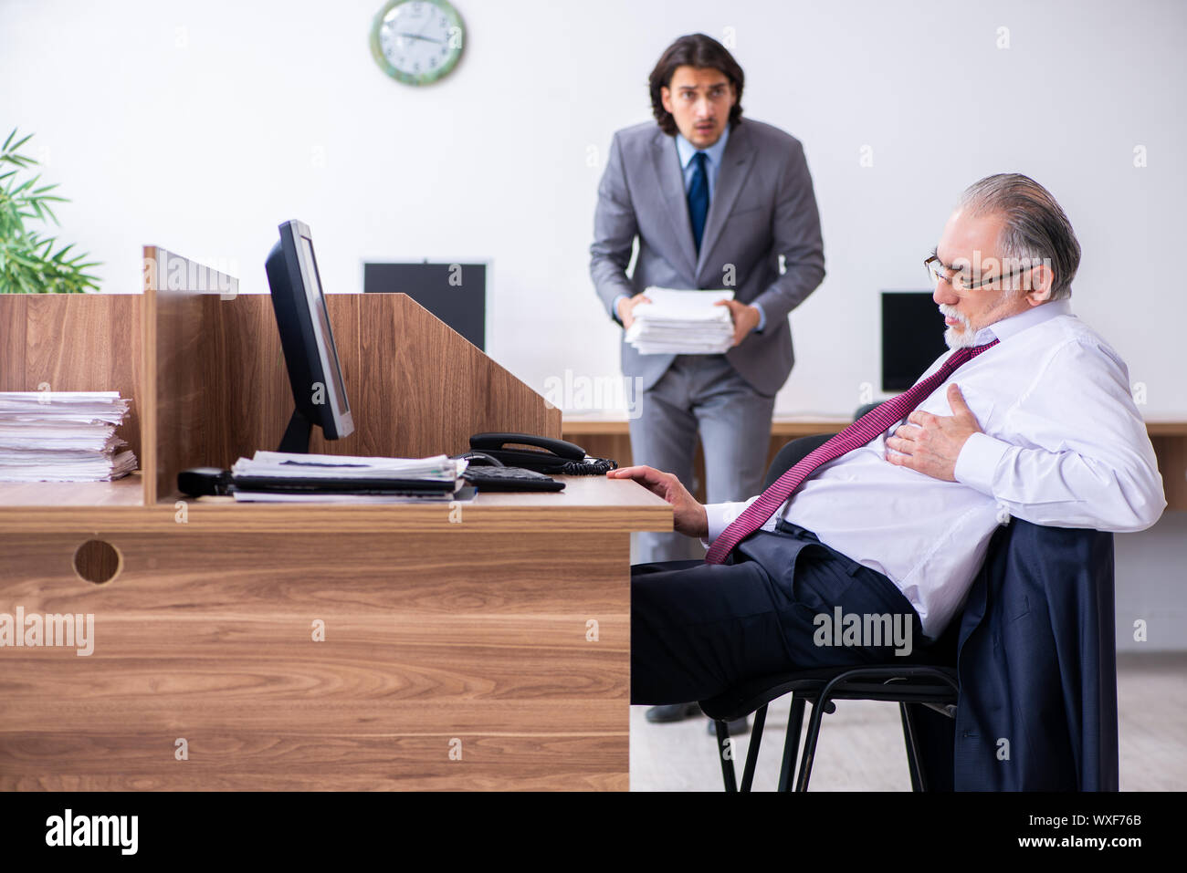 Männliche Mitarbeiter leiden von Herzinfarkt im Büro Stockfoto