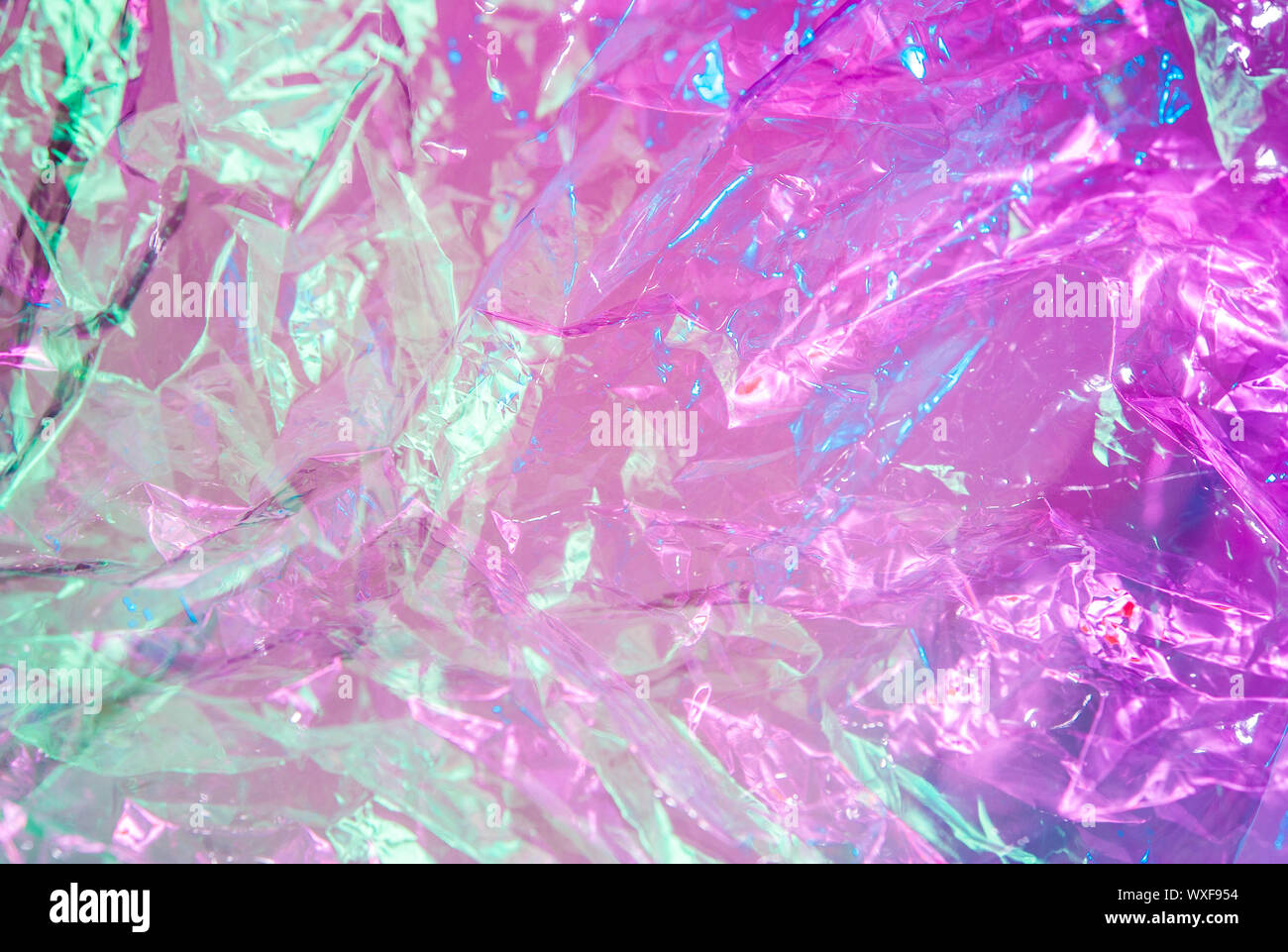 Holographische Hintergrund im Stil der 80-90 Jahre. Echten Textur von cellophan Film in hellen Säure Farben. Stockfoto