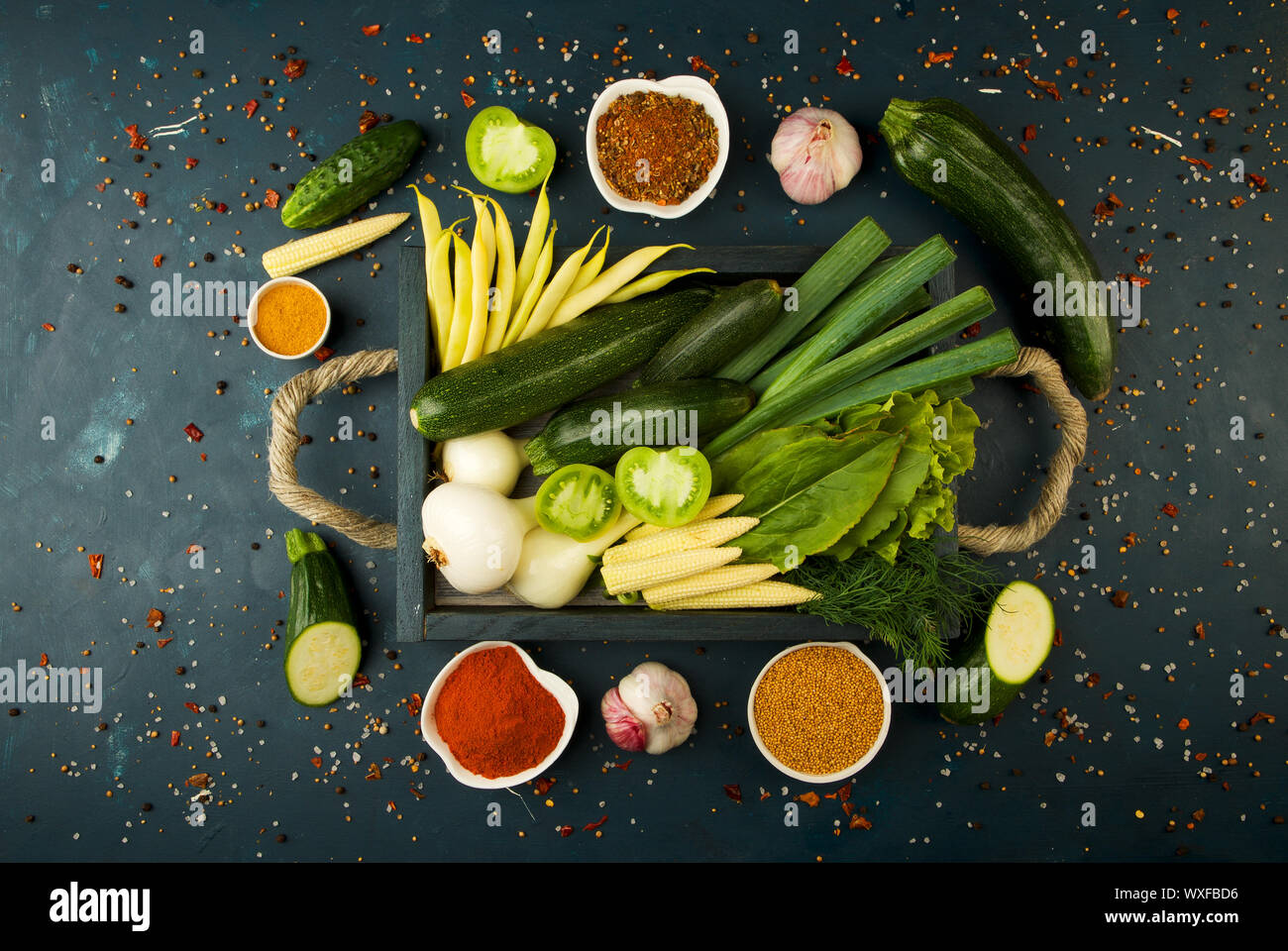 Gemüse in der Schublade mit Griffen auf einem dunklen Stein Hintergrund. Junge Kräuter Zwiebeln Knoblauch Bohnen gelber Mais ZUCCHINI HELLE SP Stockfoto