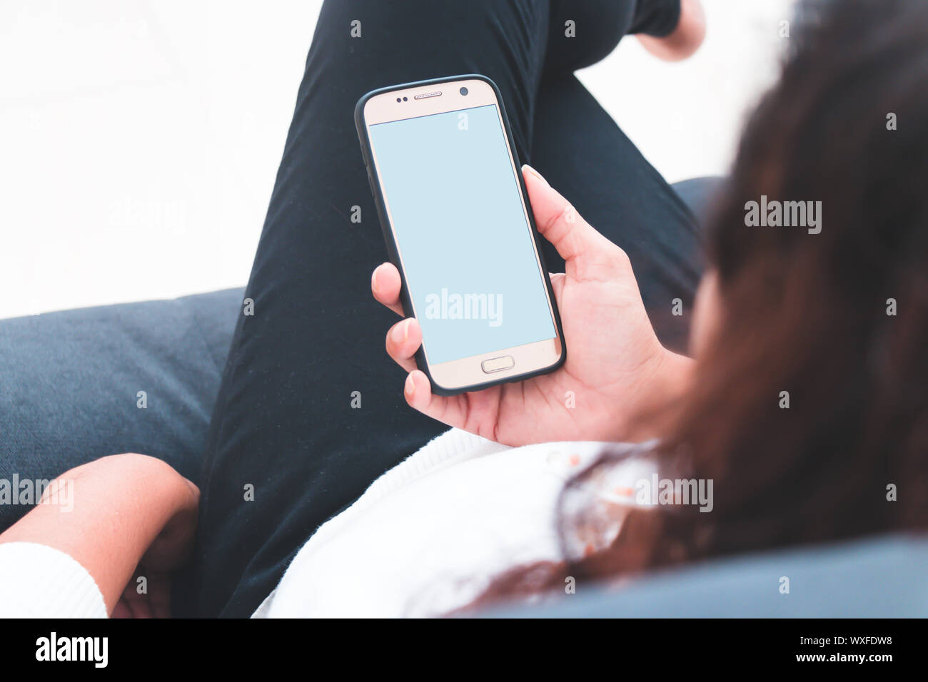 Ansicht von Hinten Nahaufnahme einer Frau hand mit einem smart phone Stockfoto
