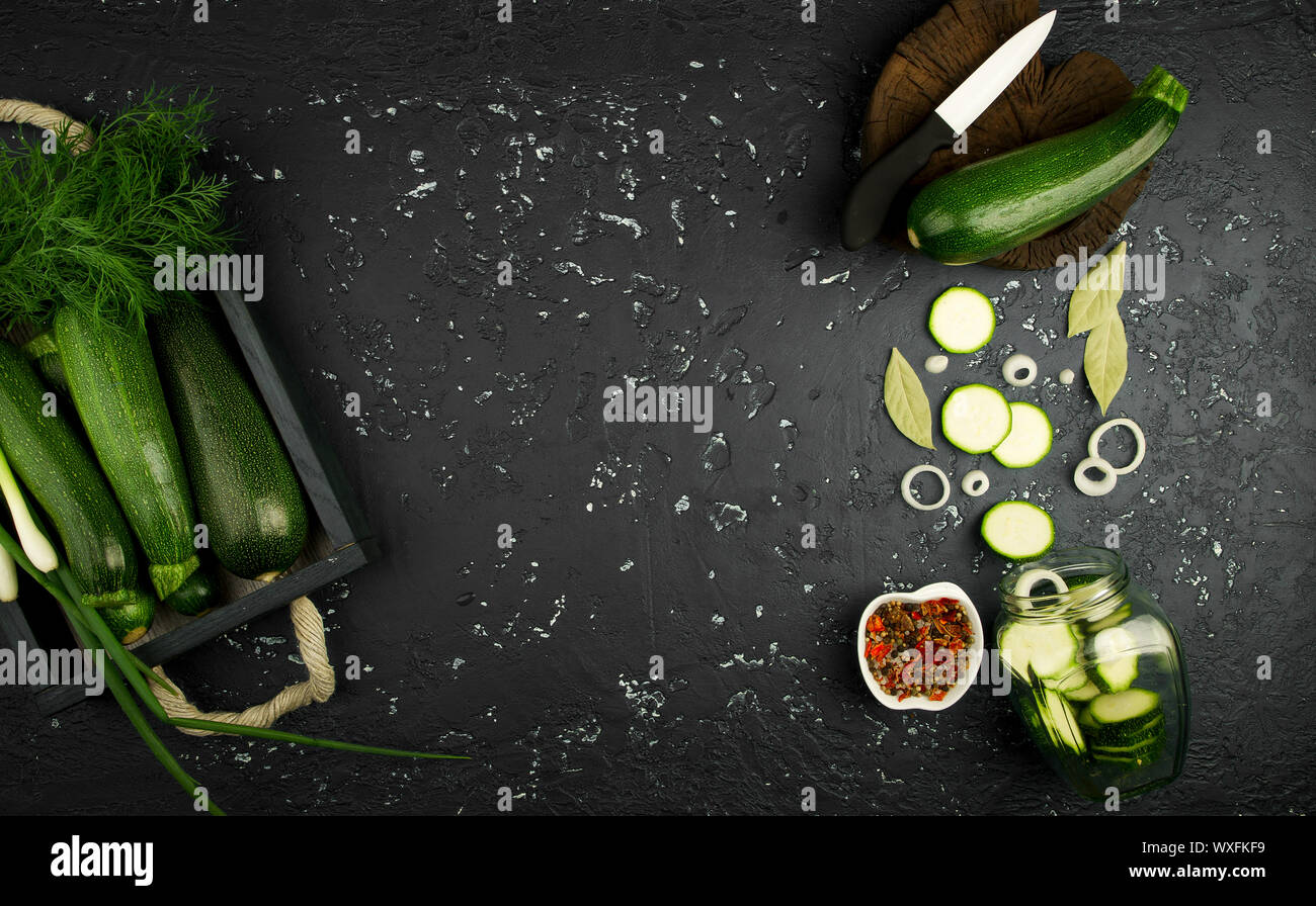 Frische grüne Zucchini auf einen dunklen Tisch. Die Aussicht von oben. Kopieren Sie Platz. Stockfoto