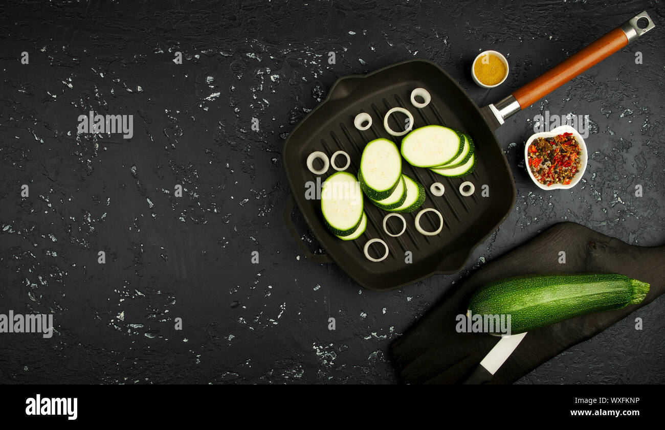 Frische grüne Zucchini auf einen dunklen Tisch. Die Aussicht von oben. Kopieren Sie Platz. Stockfoto