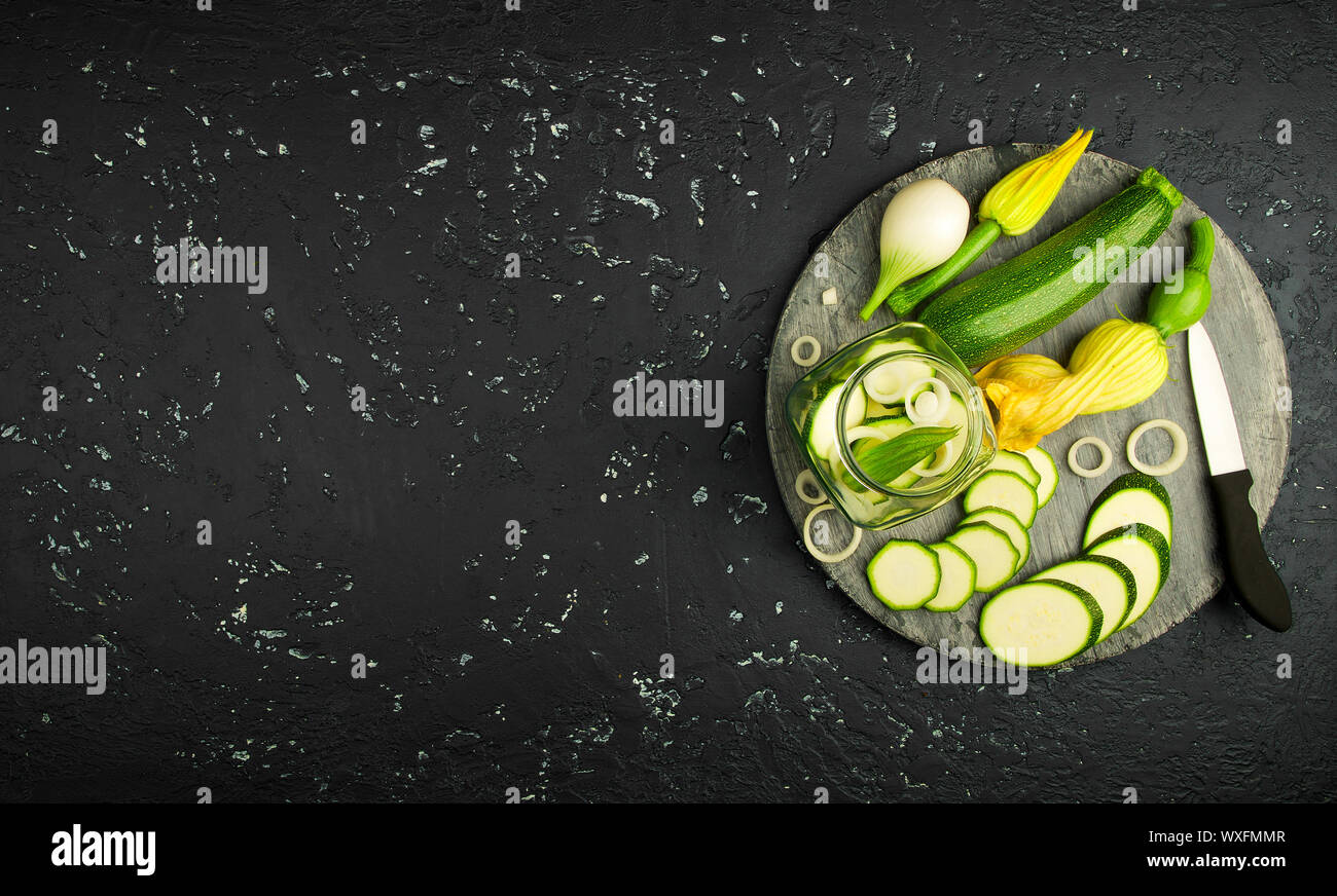 Frische grüne Zucchini auf einen dunklen Tisch. Die Aussicht von oben. Kopieren Sie Platz. Stockfoto