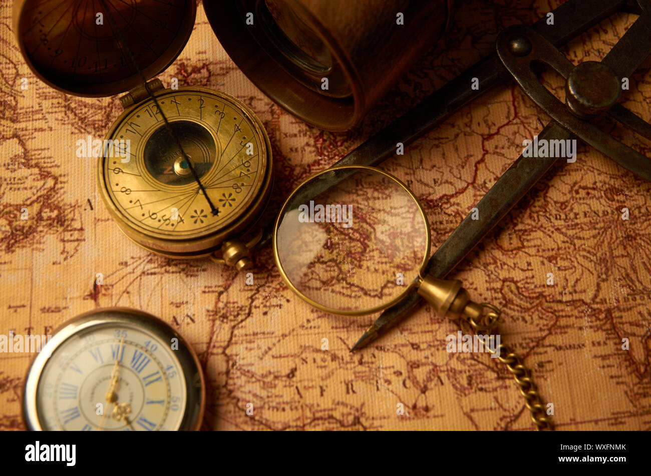 Alte Uhr mit Kompass und schändliche Rohr liegen auf Karte auf Papier Stockfoto